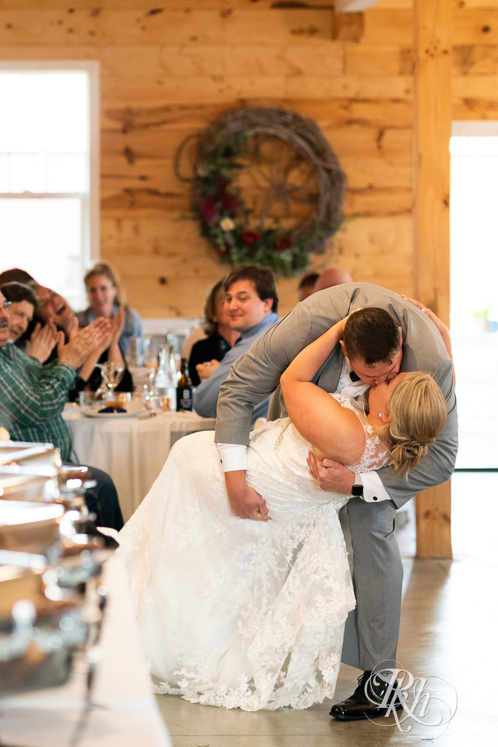 Bride and groom kiss at grand entrance at Barn at Mirror Lake in Mondovi, Wisconsin.