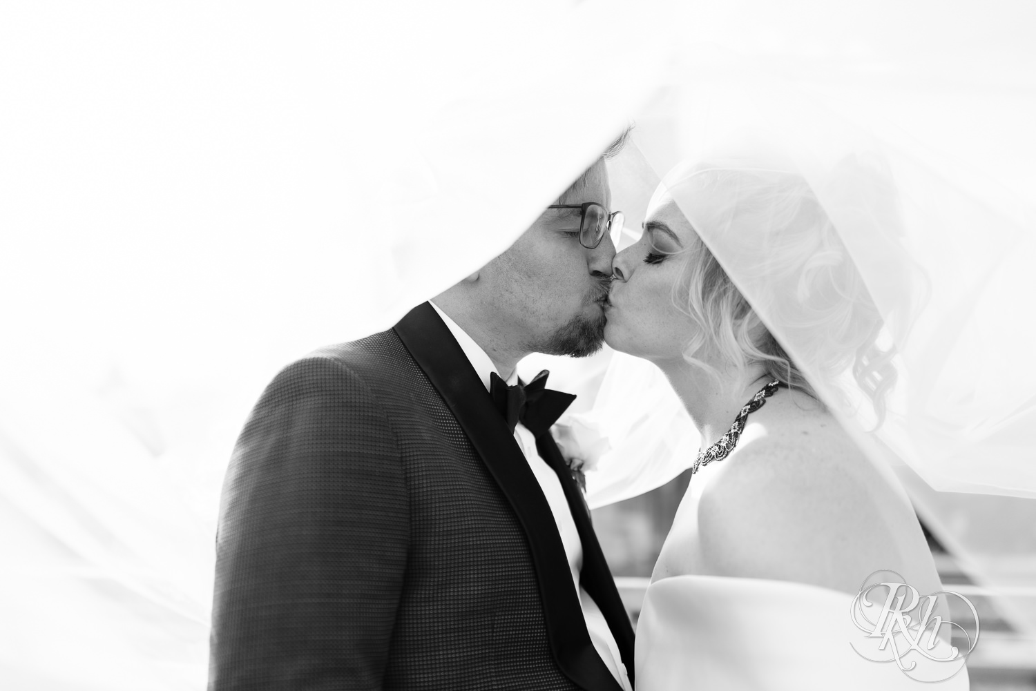 Bride and groom kiss under veil at Abulae in Saint Paul, Minnesota.