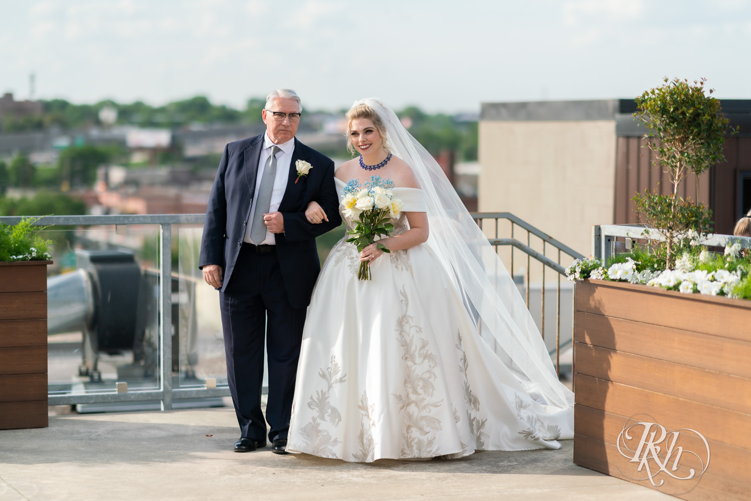 Bride walking down the aisle with father at rooftop summer wedding at Abulae in Saint Paul, Minnesota.