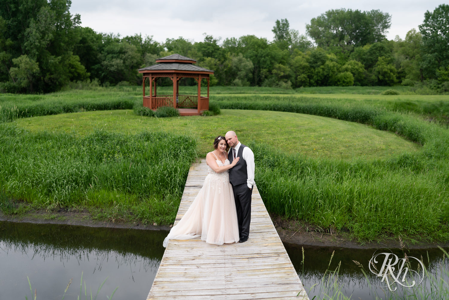 Bride and groom standing on bridge at Barn at Crocker's Creek in Faribault, Minnesota.