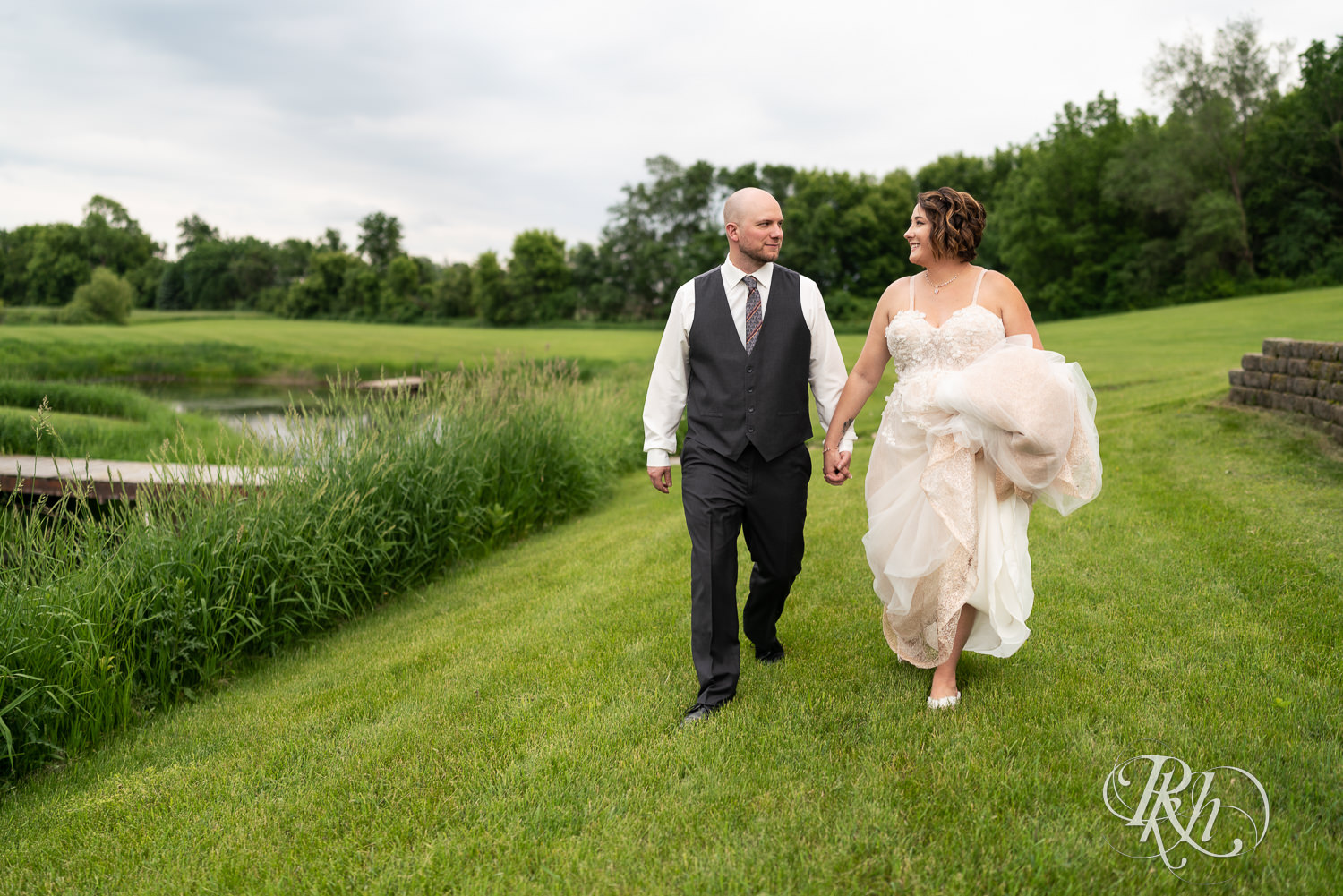Bride and groom walking holding hands at Barn at Crocker's Creek in Faribault, Minnesota.