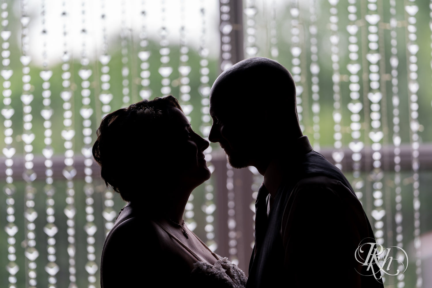Bride and groom kissing in silhouette at Barn at Crocker's Creek in Faribault, Minnesota.