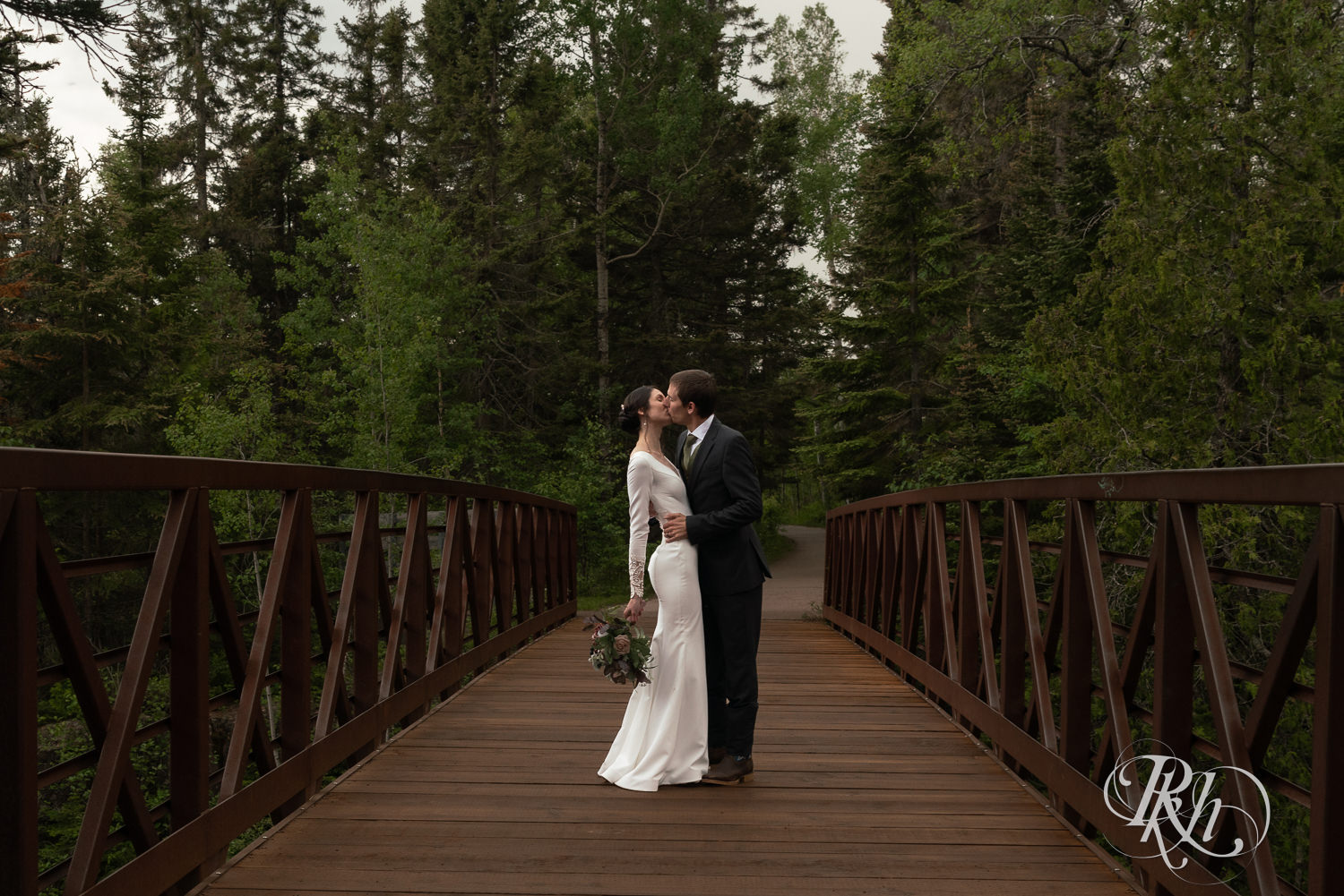 Bride and groom kiss on a bridge at their North Shore elopement in Tofte, Minnesota.