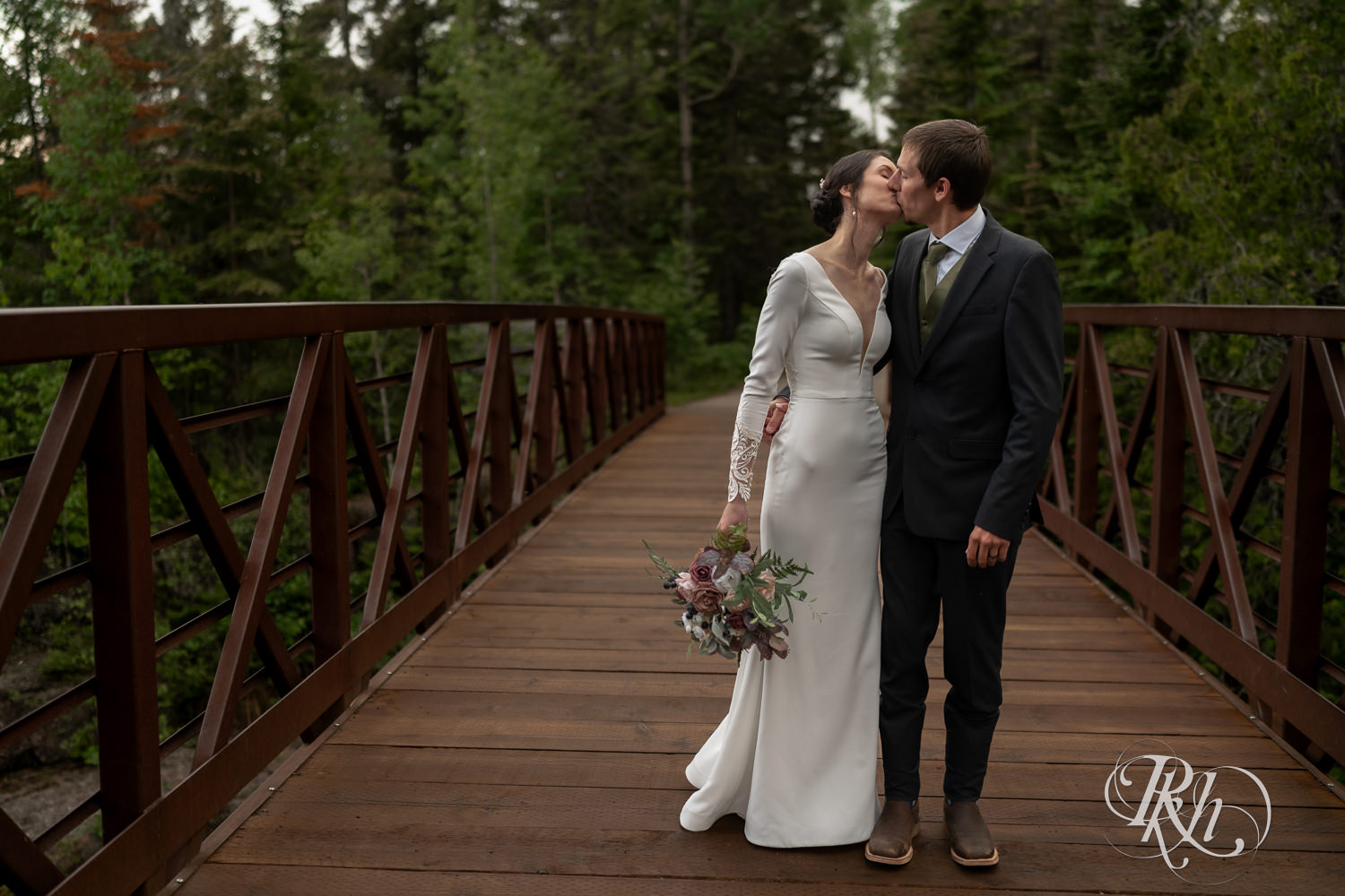 Bride and groom kiss on a bridge at their North Shore elopement in Tofte, Minnesota.
