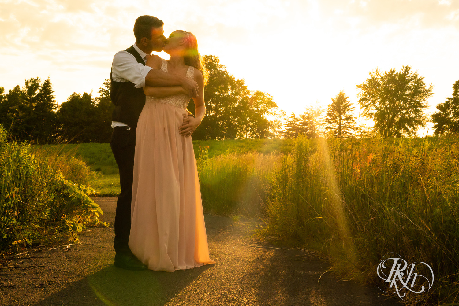 Bride and groom kissing at sunset at The Outpost Center in Chaska, Minnesota.