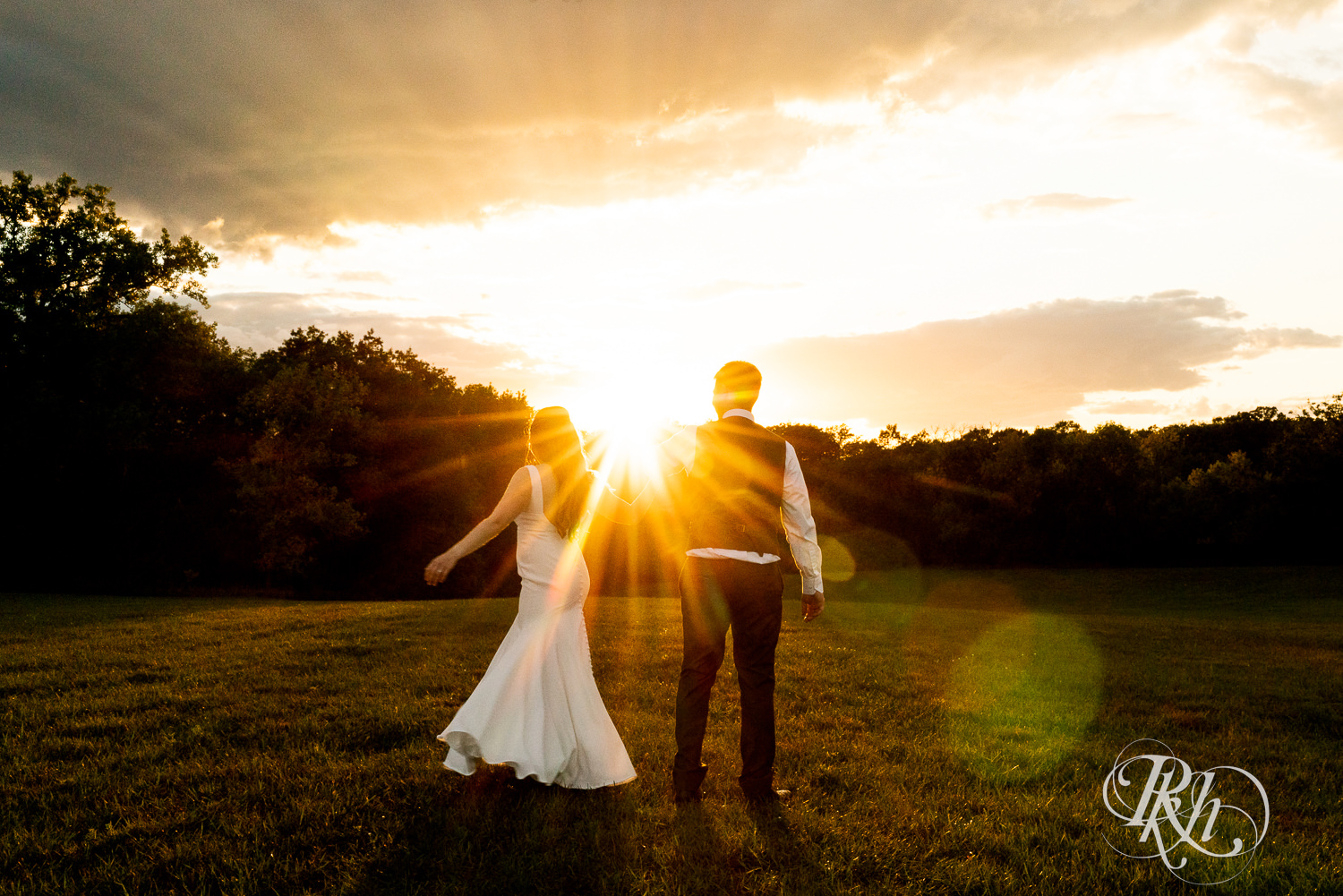 Bride and groom walking into sunset at Stone Lion Winery and Events in Isanti, Minnesota. 