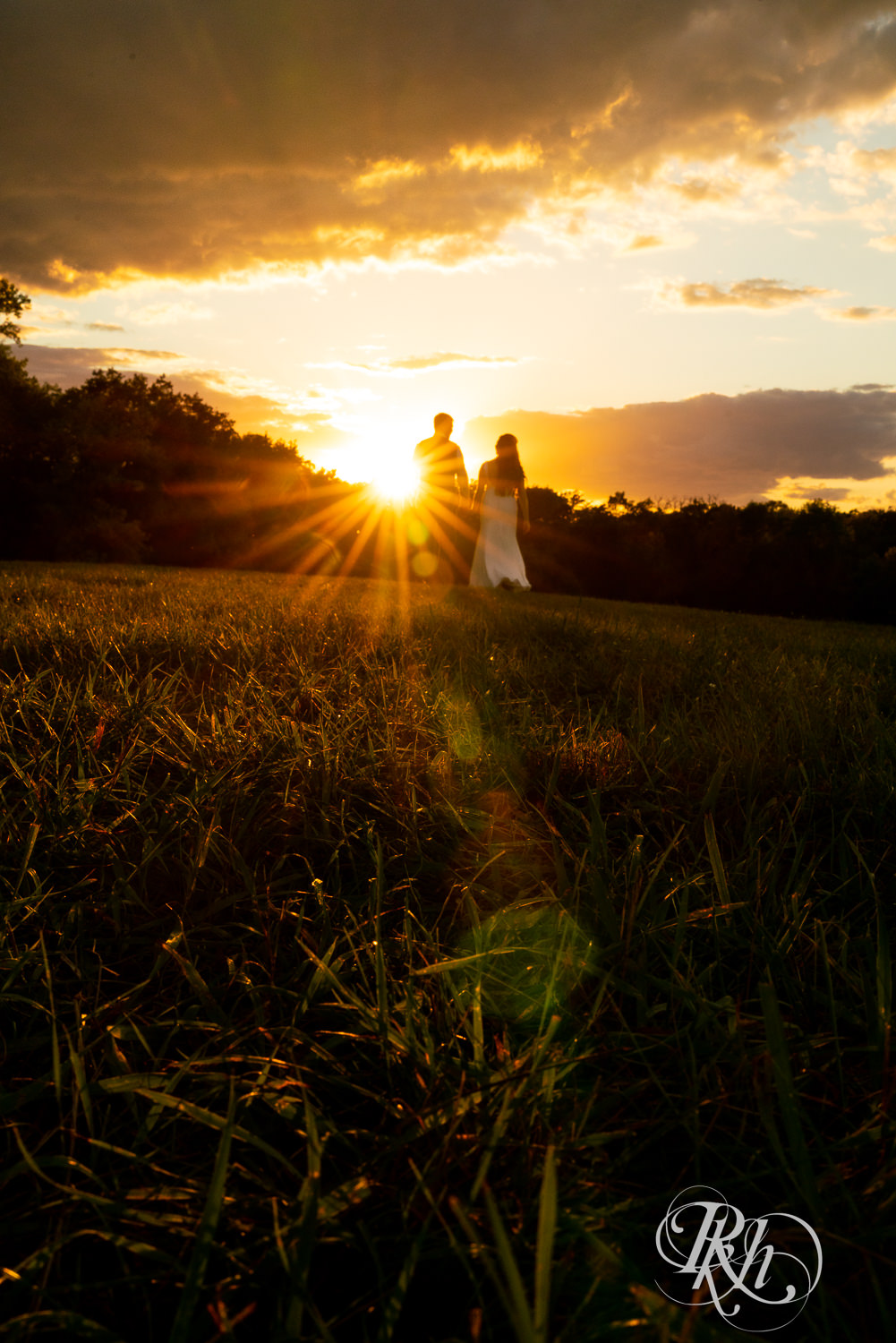 Bride and groom walking into sunset at Stone Lion Winery and Events in Isanti, Minnesota. 