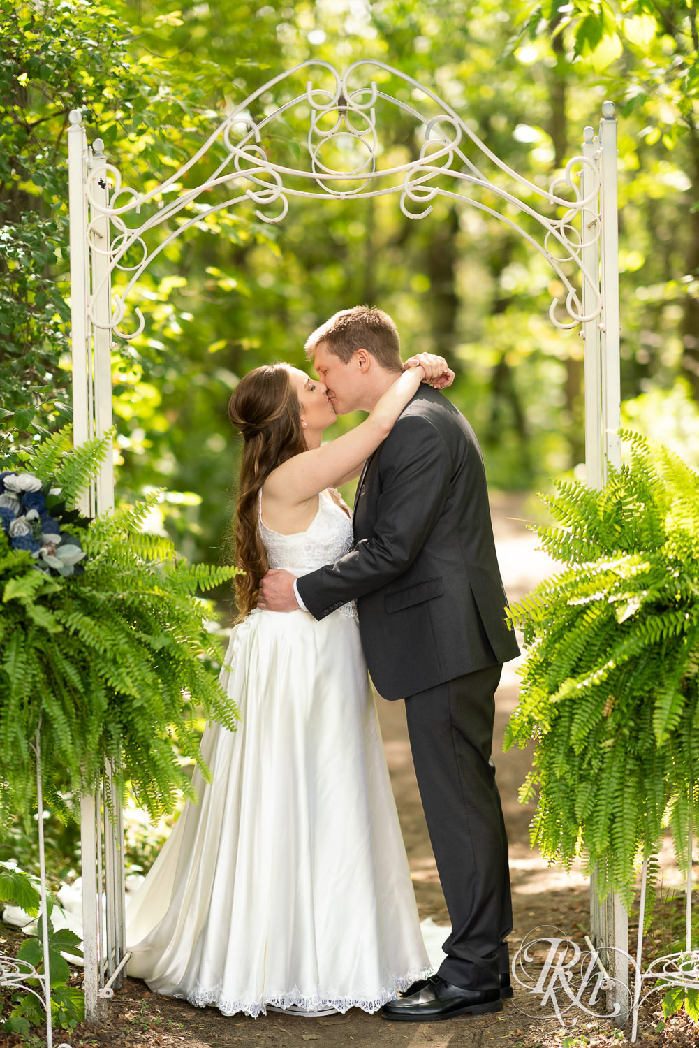 Bride and groom kissing at a summer wedding at Stone Lion Winery and Events in Isanti, Minnesota. 