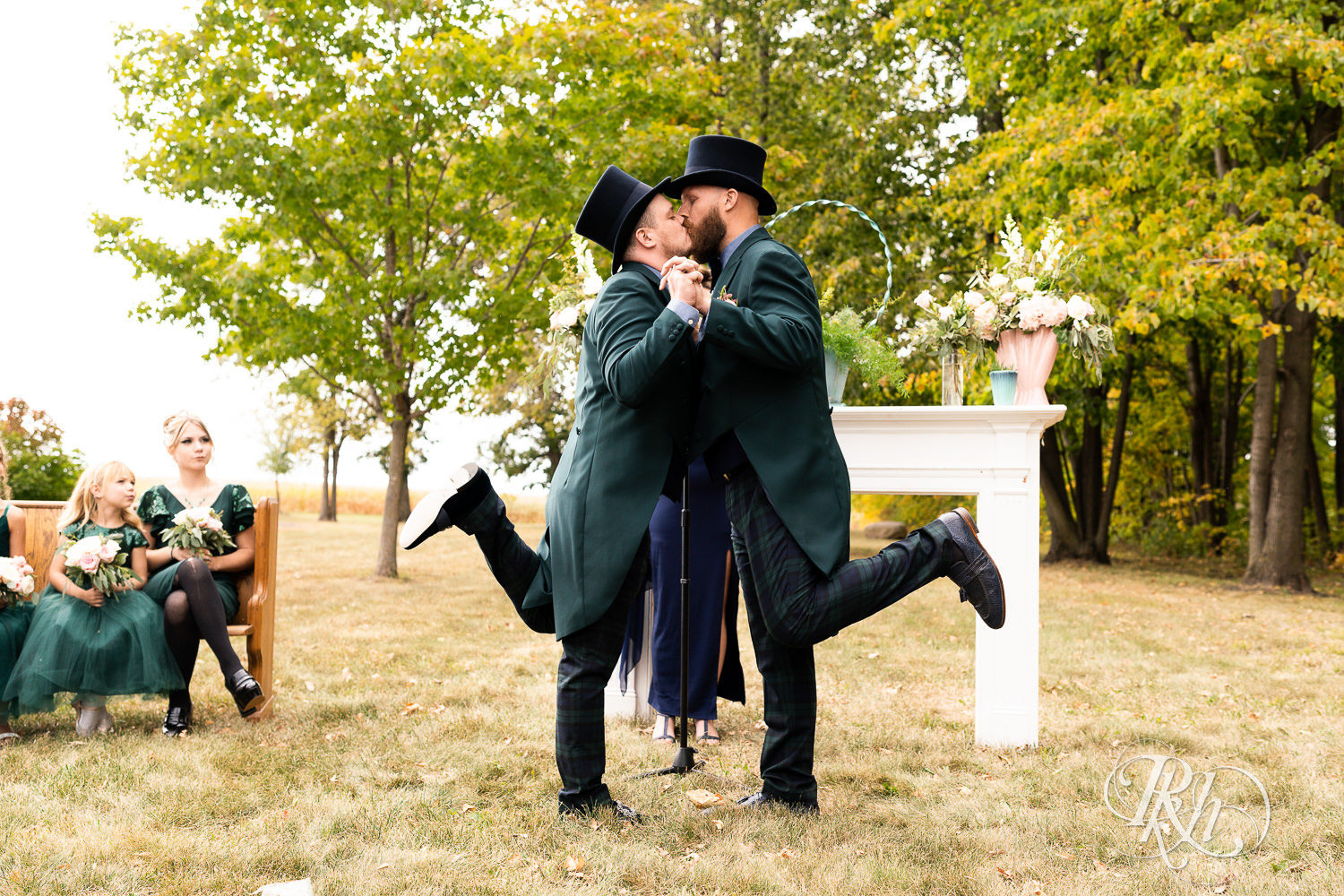 Grooms sharing first kiss at their ceremony in Belle Plaine, Minnesota.