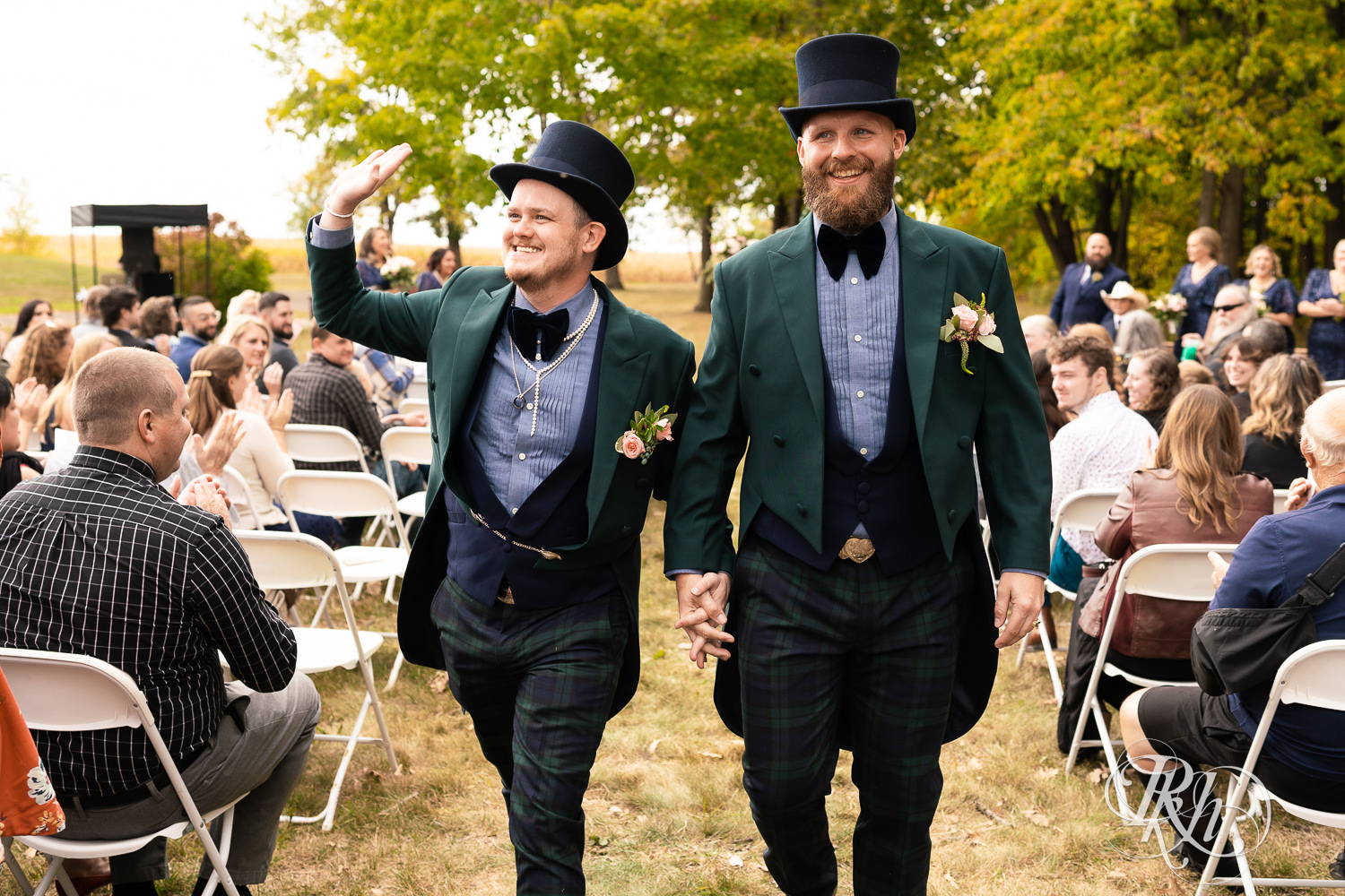 Grooms smiling and waving walking down the aisle on wedding day in Belle Plaine, Minnesota.