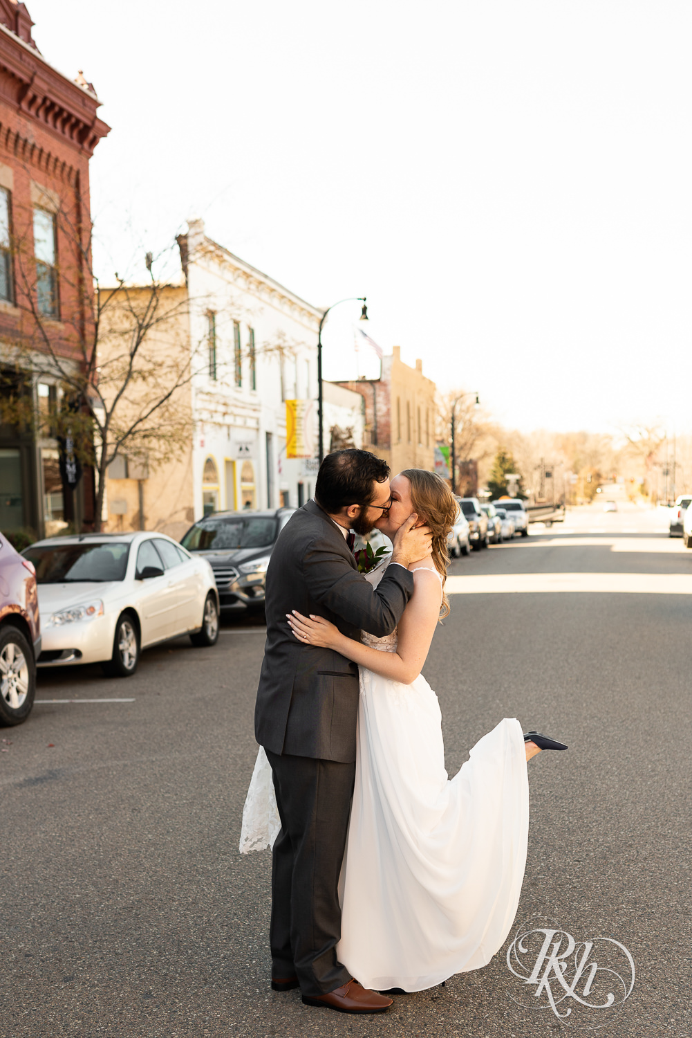 Bride and groom kissing in front of The Jerome Event Center in Delano, Minnesota.