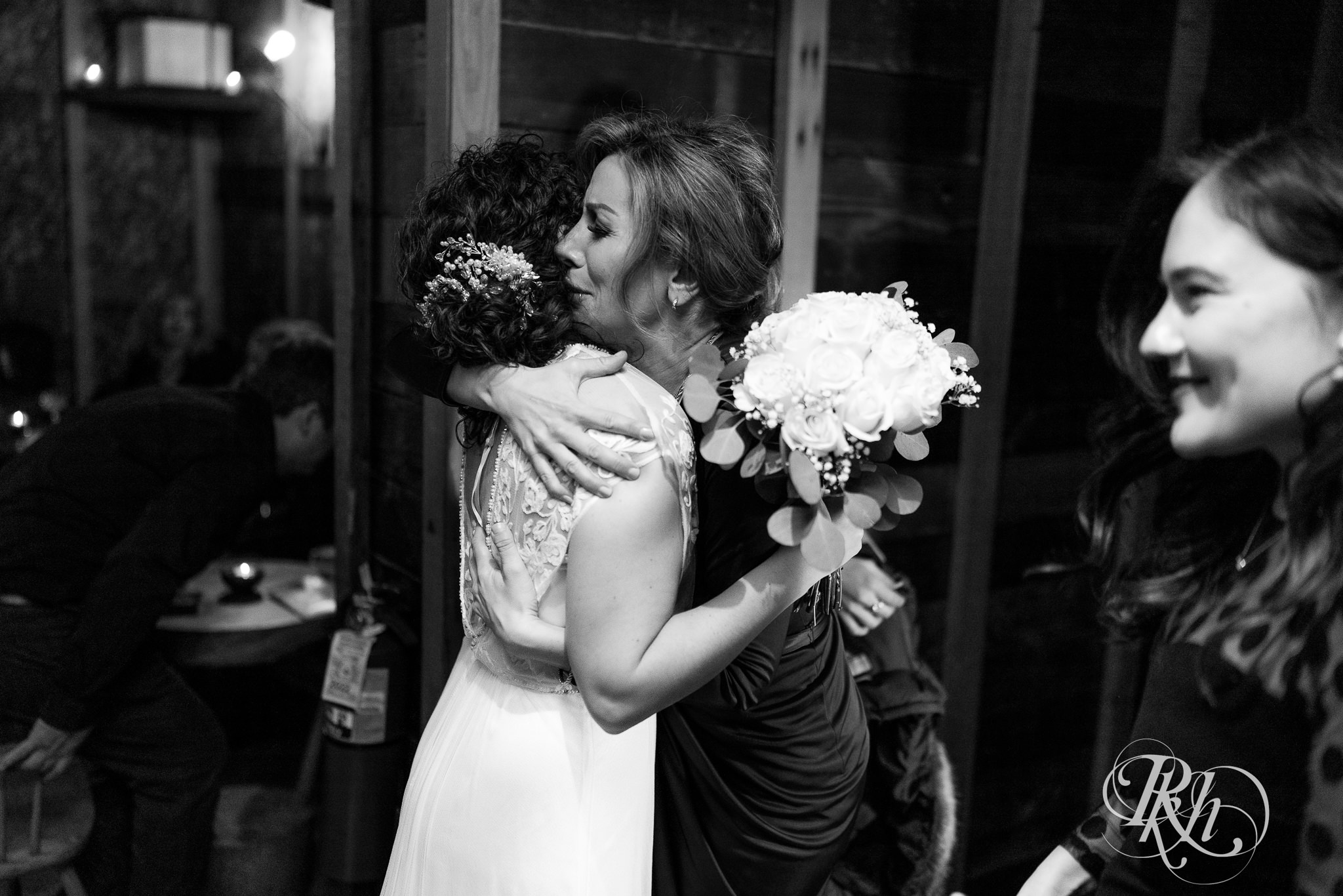Woman hugging a bride at Young Joni in Minneapolis, Minnesota.