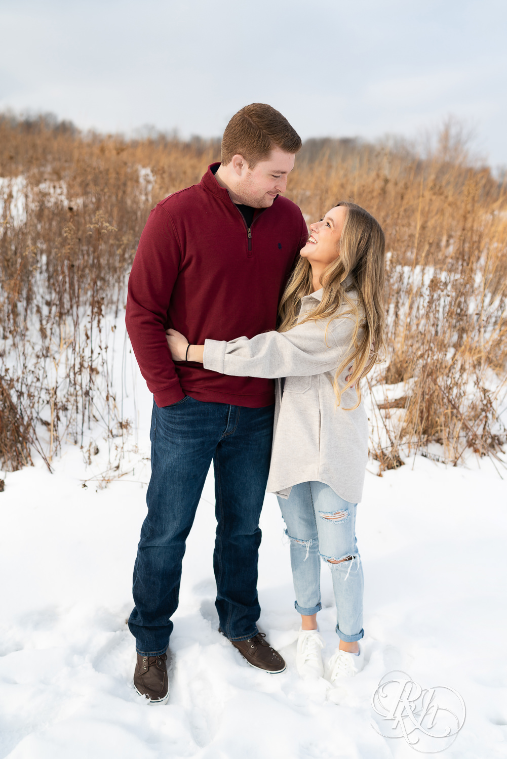 Couple hugging looking at each other in the snow.