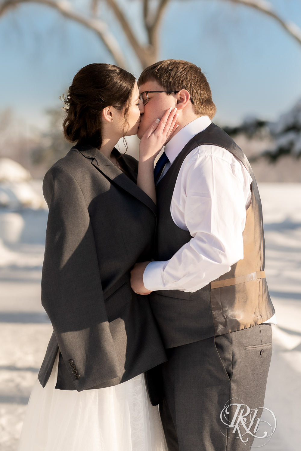 Bride and groom kissing in snow outside at Minneapolis Golf Club in Saint Louis Park, Minnesota.