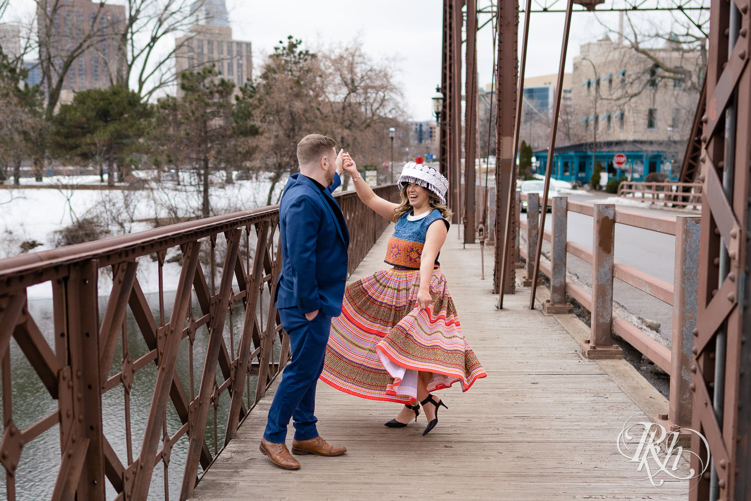 Man and Hmong woman dance on bridge in Saint Anthony Main in Minneapolis, Minnesota.