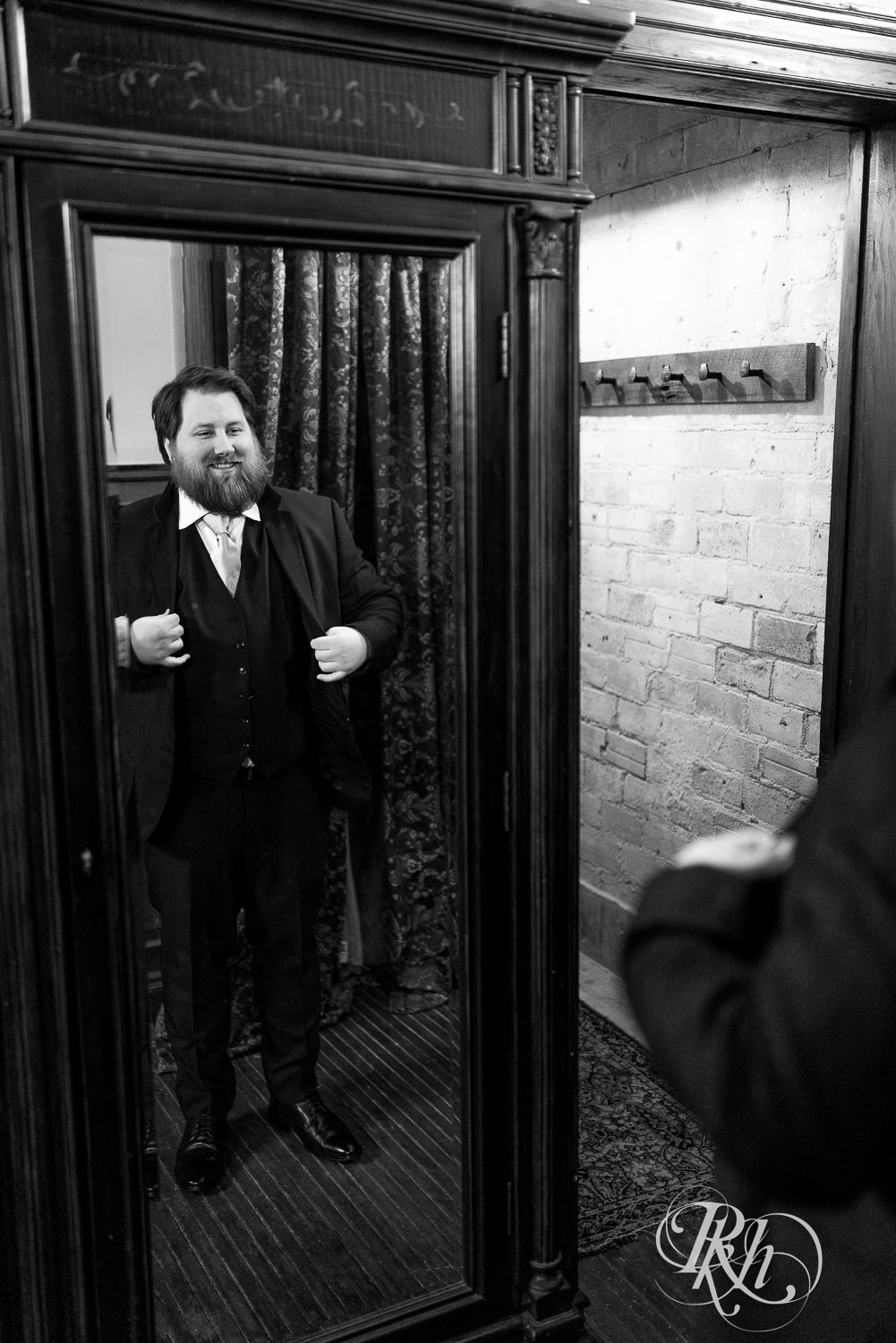 Groom putting on suit before wedding at Semple Mansion in Minneapolis, Minnesota.