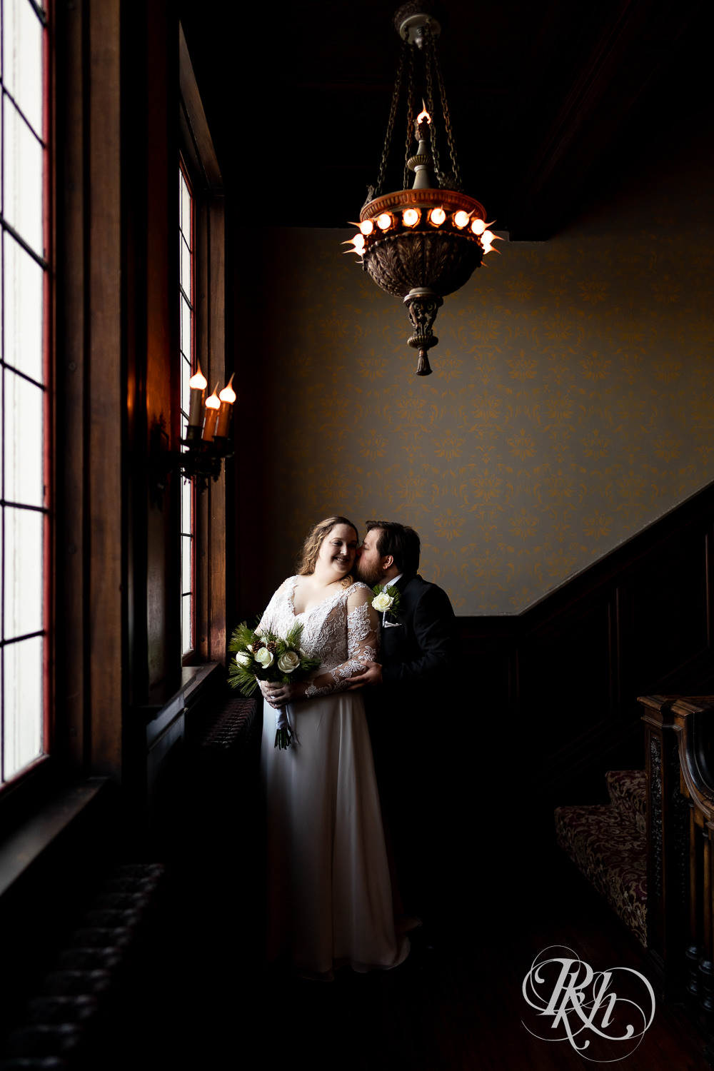 Bride and groom kissing next to window at Semple Mansion in Minneapolis, Minnesota.