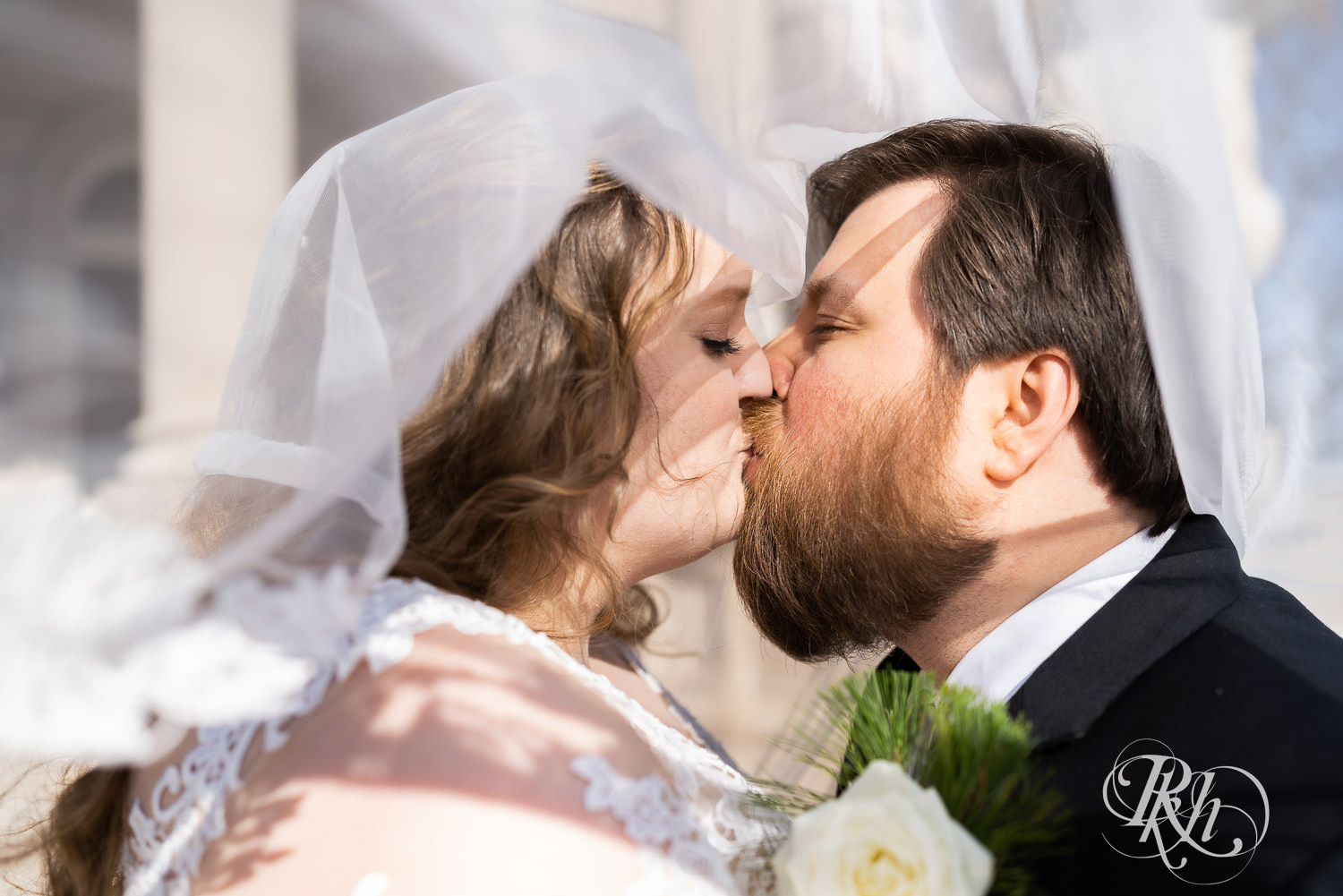 Bride and groom kissing under veil at Semple Mansion in Minneapolis, Minnesota.