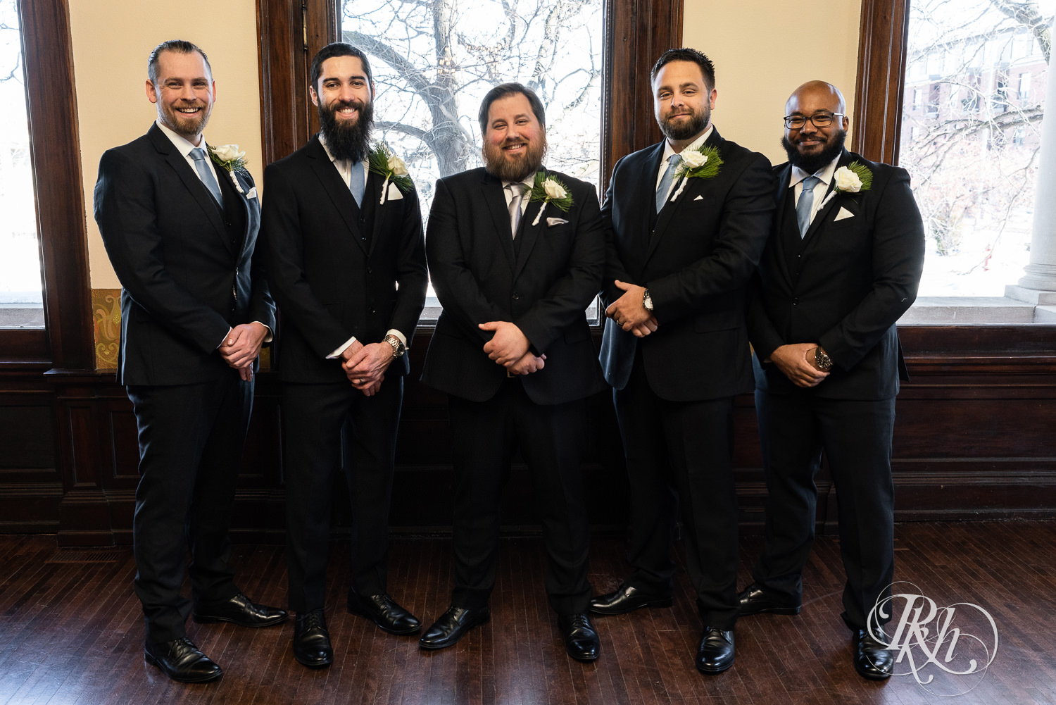 Wedding party in black suits smiling at Semple Mansion in Minneapolis, Minnesota.