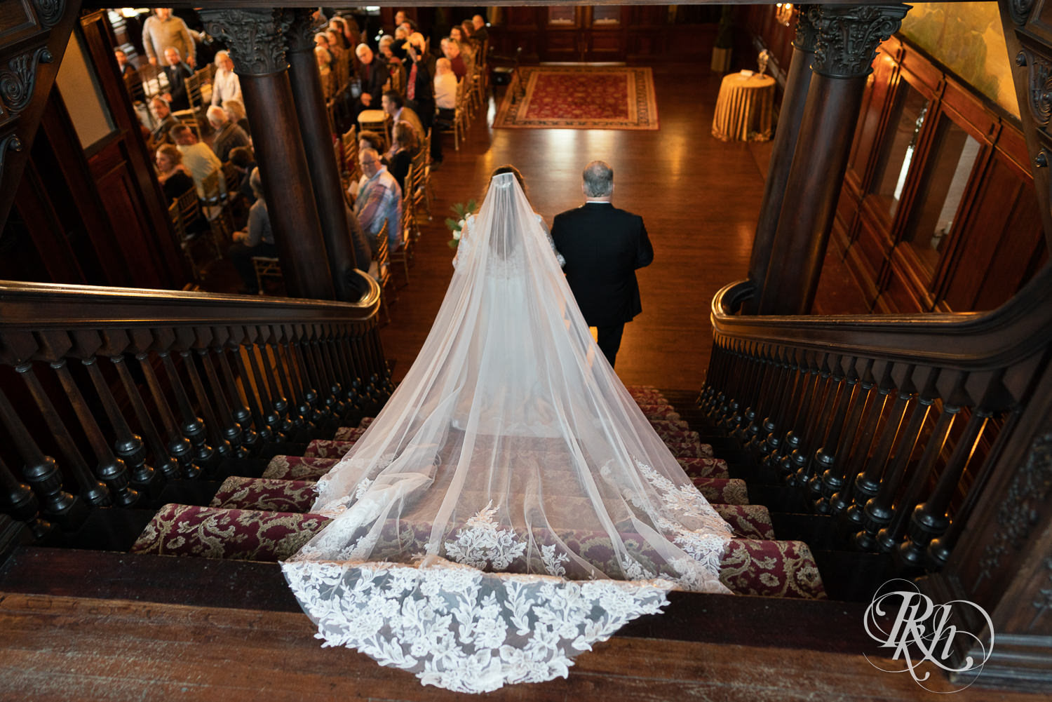Bride walking down the stairs with her dad at Semple Mansion in Minneapolis, Minnesota.
