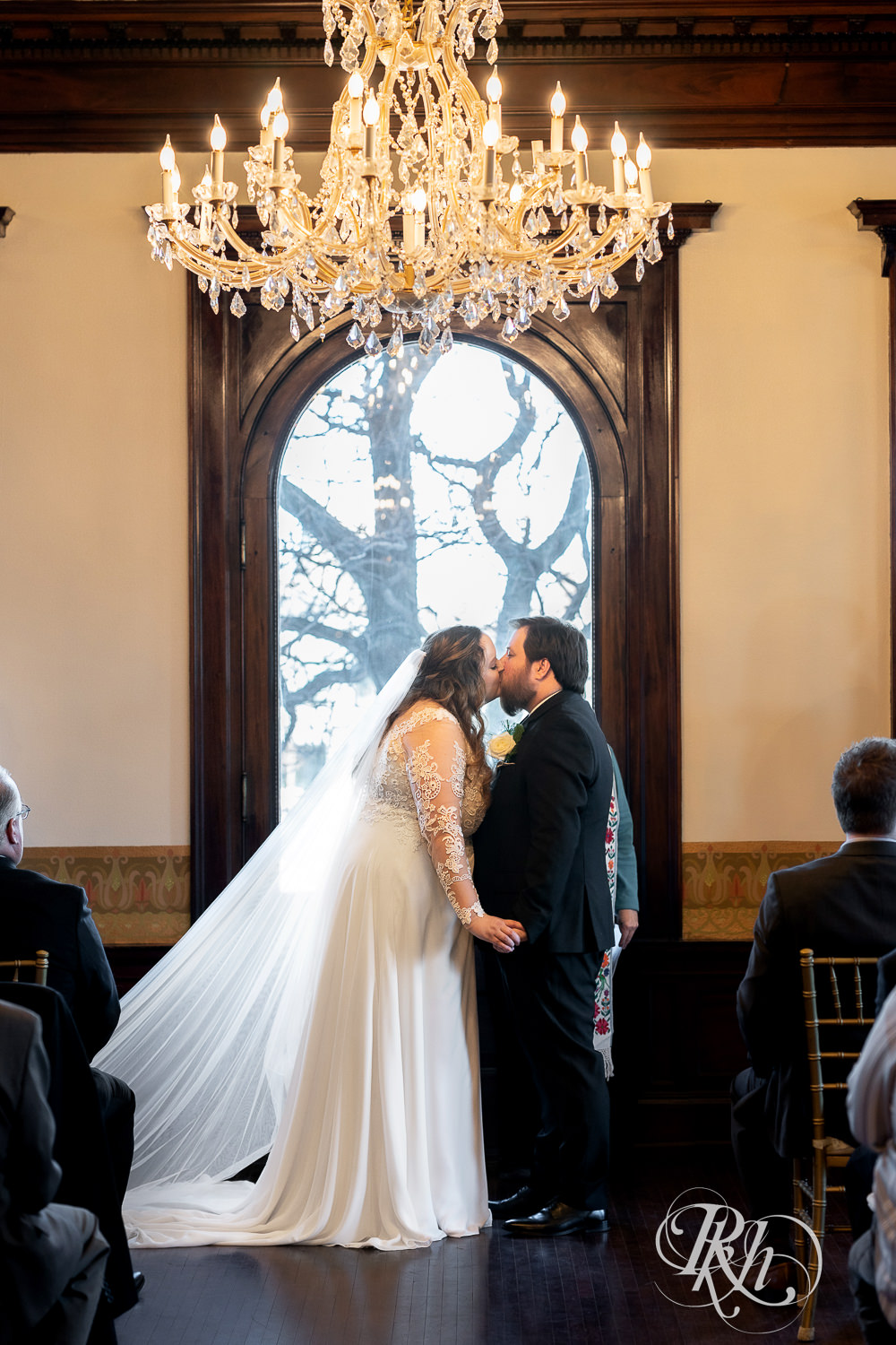 Bride and groom kiss at the wedding ceremony at Semple Mansion in Minneapolis, Minnesota.