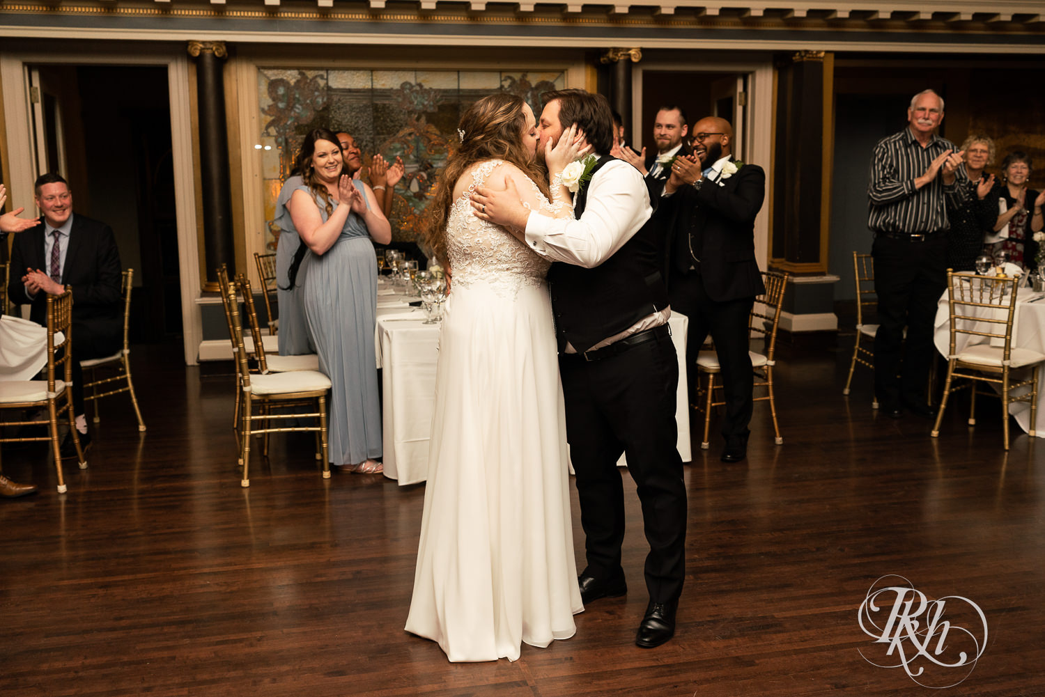 Bride and groom kiss at grand entrance at Semple Mansion in Minneapolis, Minnesota.