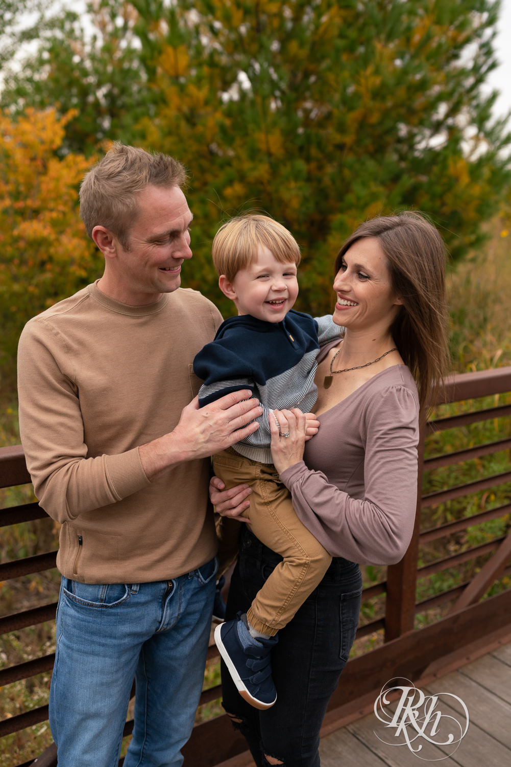 Minnesota outdoor family photography of little boy laughing with parents at Whitetail Woods in Farmington, Minnesota.