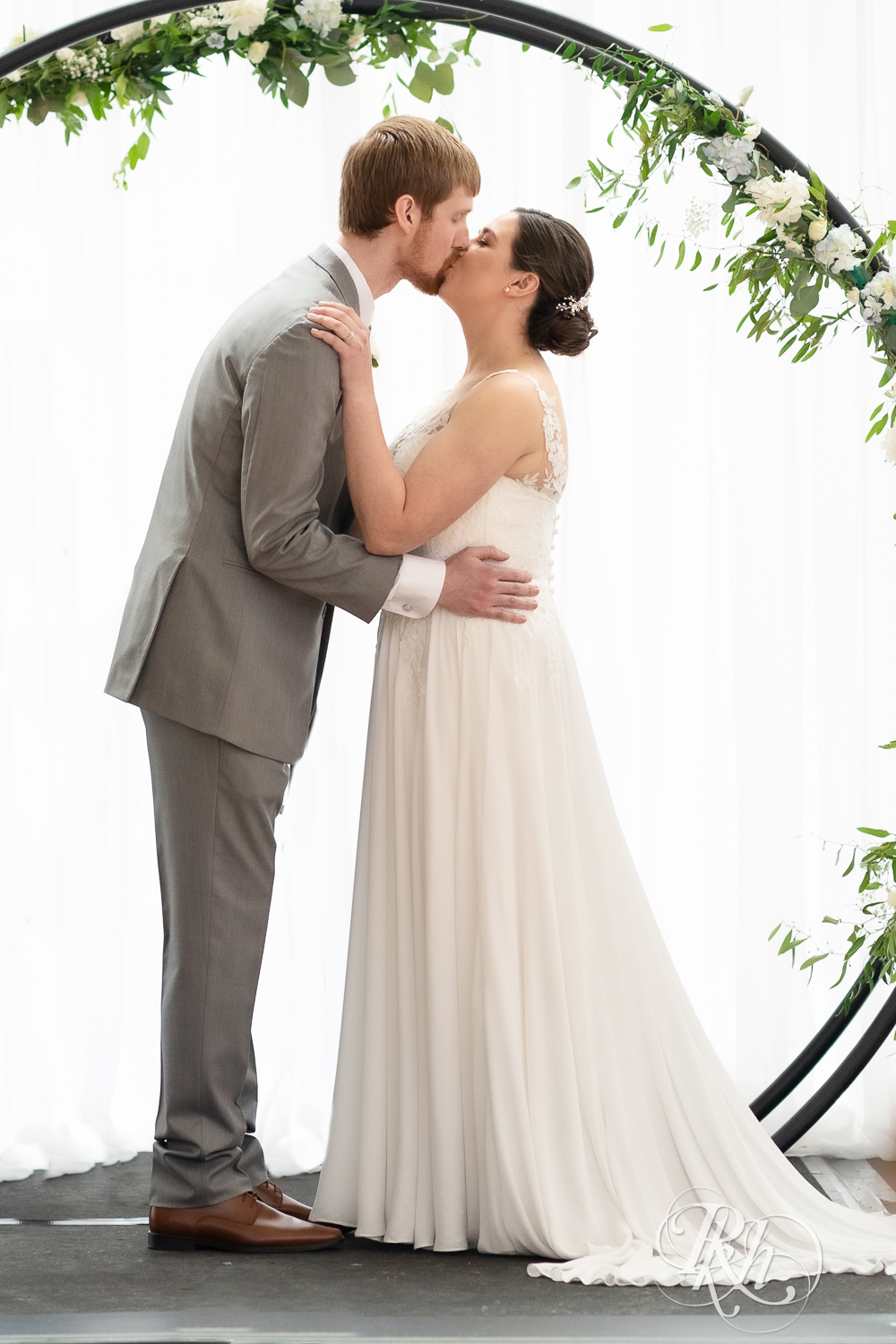 Bride and groom kiss during wedding ceremony at Doubletree Hilton Saint Paul in Saint Paul, Minnesota.
