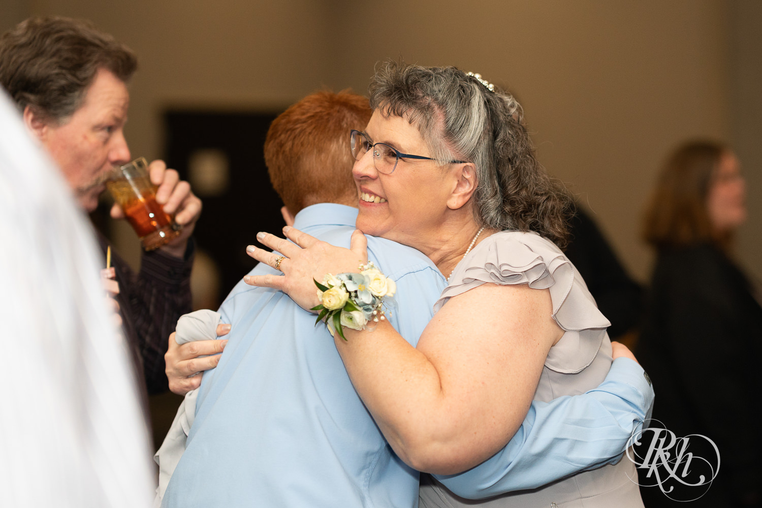 Guests hug at wedding reception at Doubletree Hilton Saint Paul in Saint Paul, Minnesota.