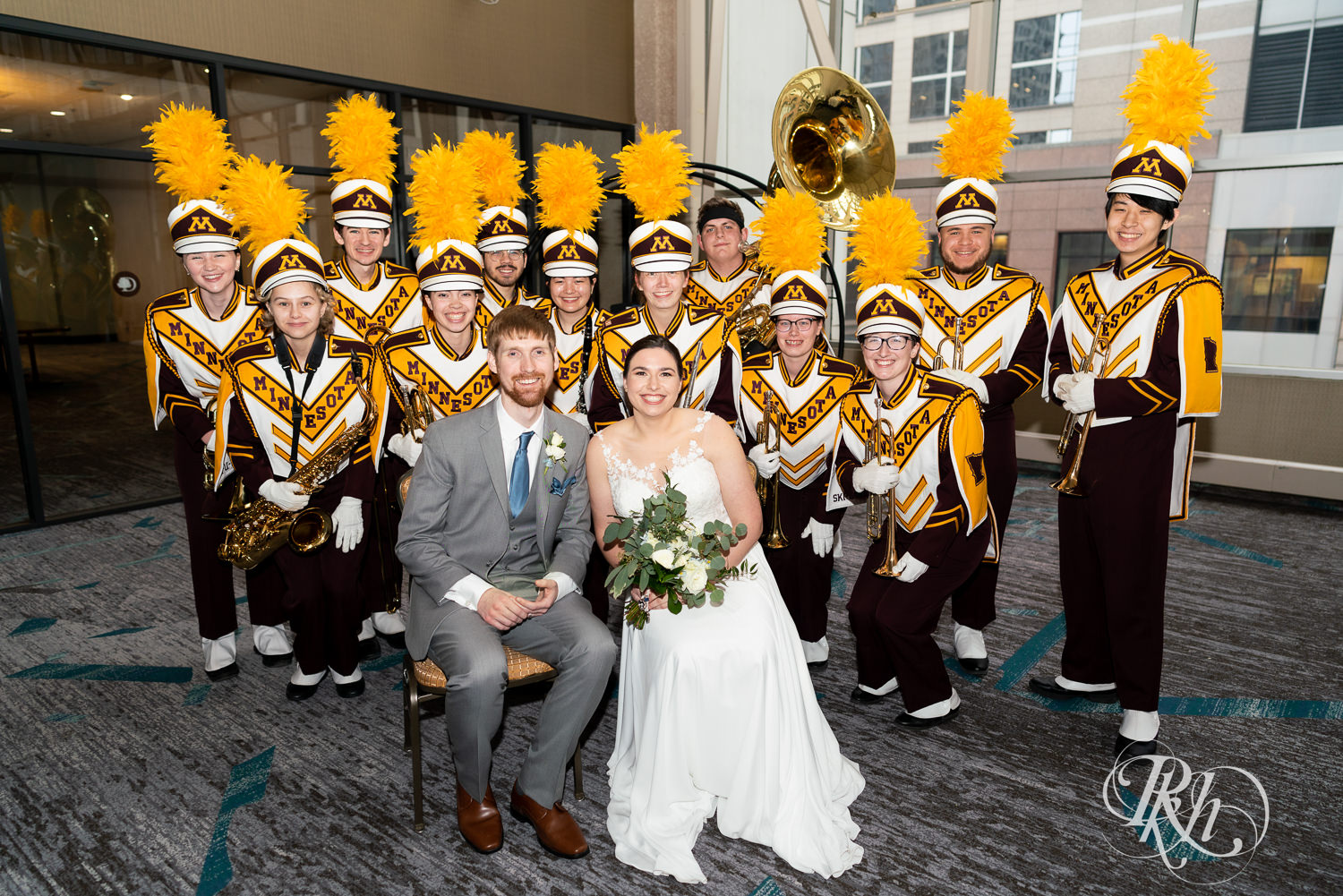 Bride and groom smile with University of Minnesota Brass Quintet at wedding reception at Doubletree Hilton Saint Paul in Saint Paul, Minnesota.