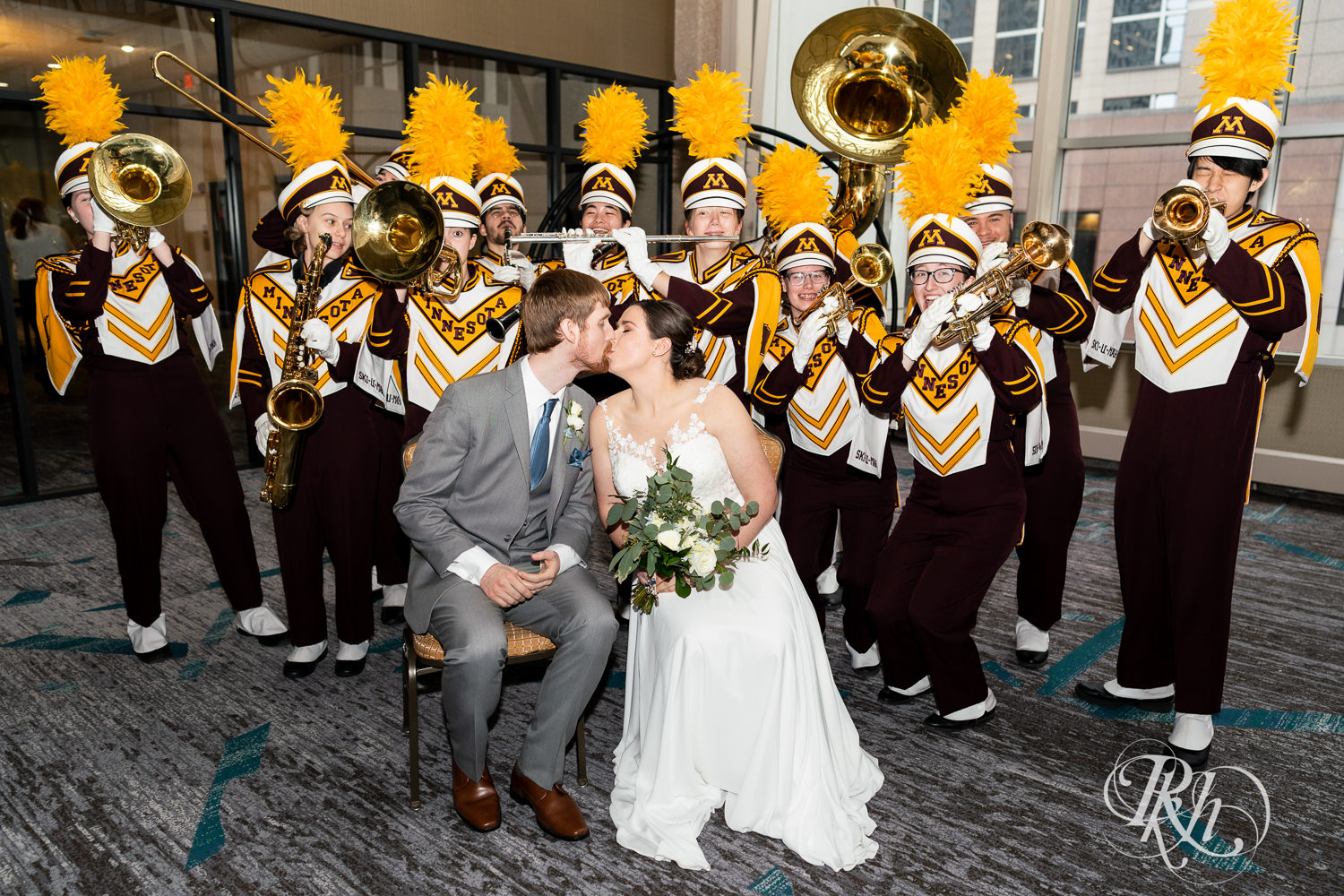 Bride and groom smile with University of Minnesota Brass Quintet at wedding reception at Doubletree Hilton Saint Paul in Saint Paul, Minnesota.