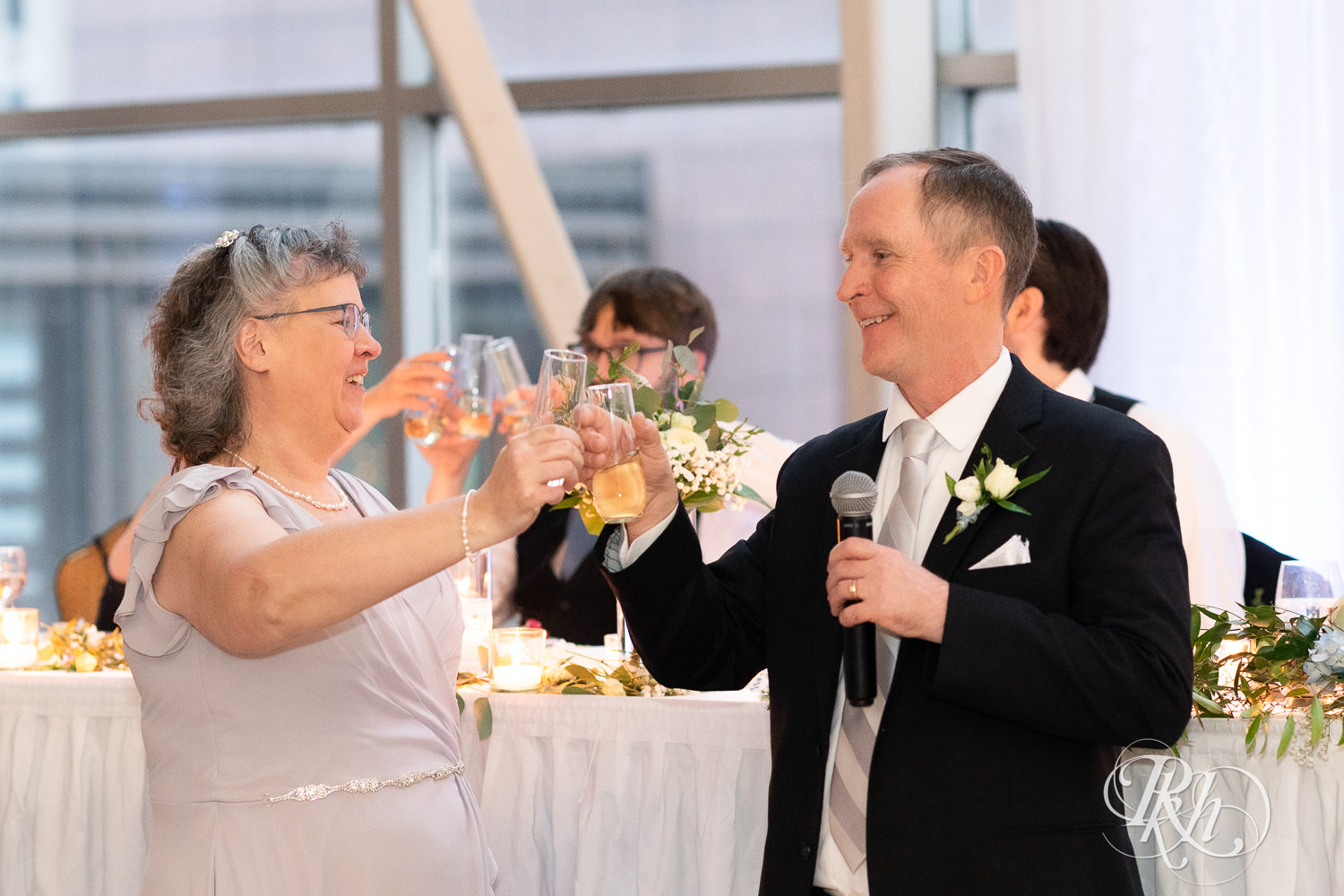 Mom and dad toast during wedding speeches at Doubletree Hilton Saint Paul in Saint Paul, Minnesota.