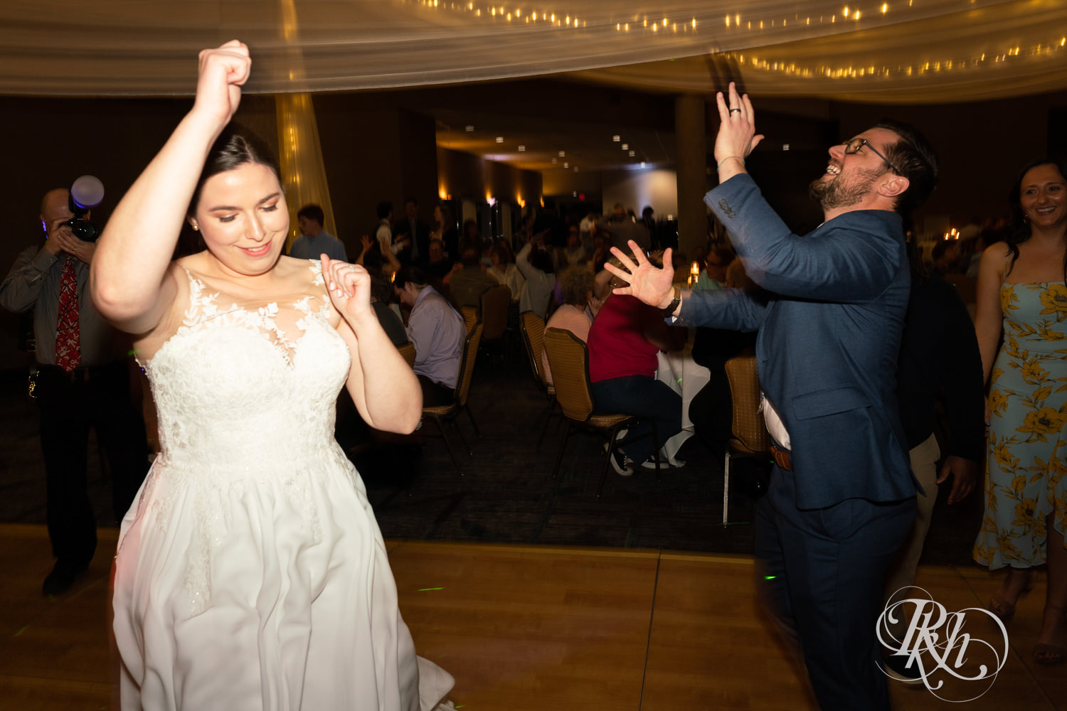 Bride and groom dance with guests at wedding reception at Doubletree Hilton Saint Paul in Saint Paul, Minnesota.