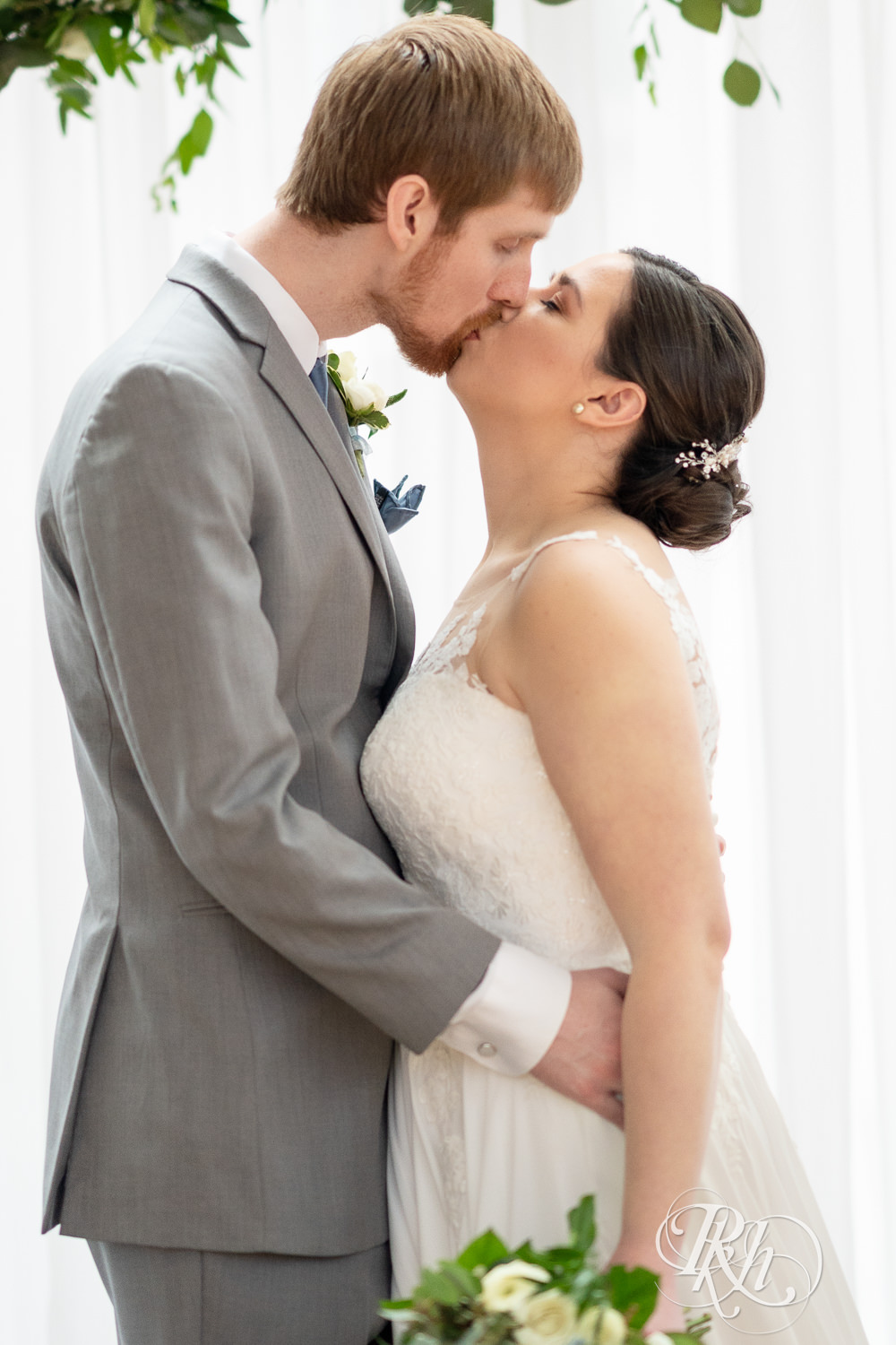 Bride and groom kiss on alter at Doubletree Hilton Saint Paul in Saint Paul, Minnesota.