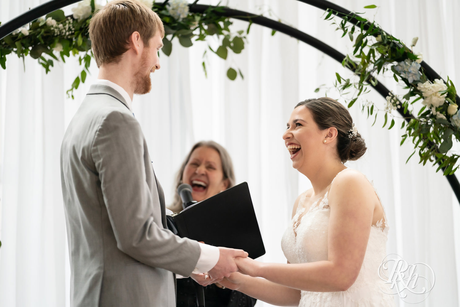 Bride and groom smile during wedding ceremony at Doubletree Hilton Saint Paul in Saint Paul, Minnesota.