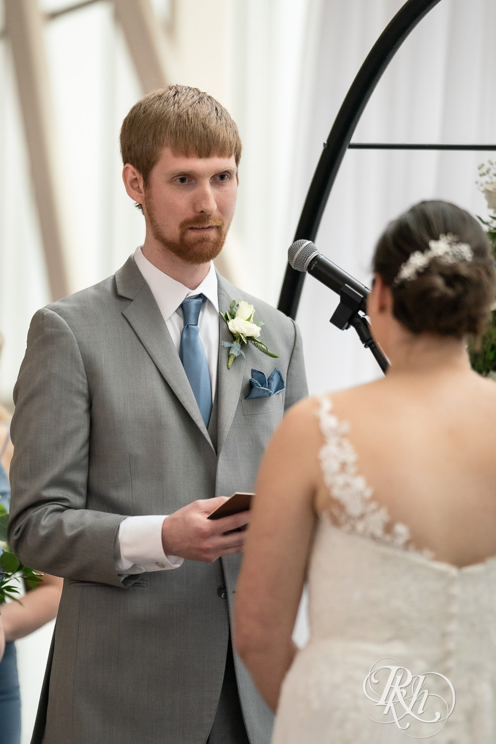 Groom reads vows during wedding ceremony at Doubletree Hilton Saint Paul in Saint Paul, Minnesota.
