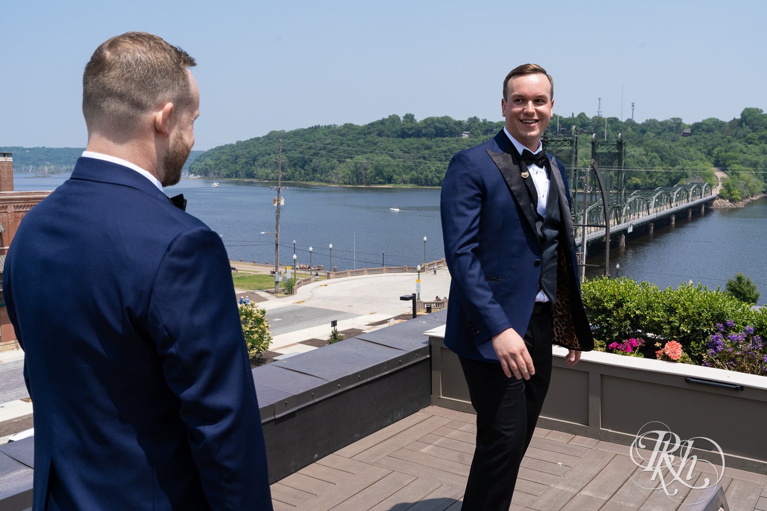 Grooms do first look on rooftop before gay wedding in Stillwater, Minnesota.