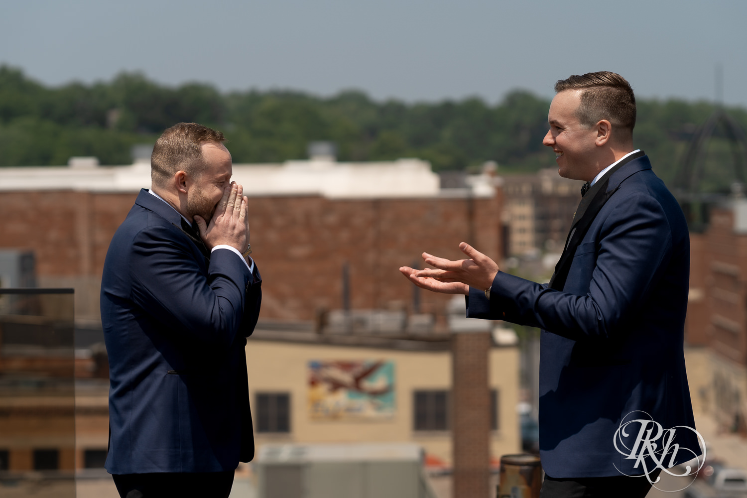 Grooms cries during first look on rooftop before gay wedding in Stillwater, Minnesota.