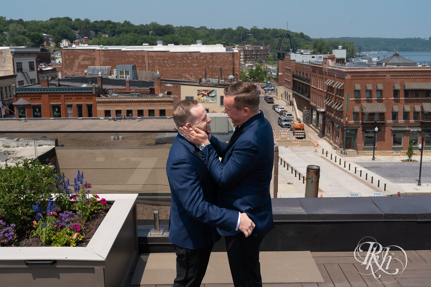 Grooms hug during first look on rooftop before gay wedding in Stillwater, Minnesota.
