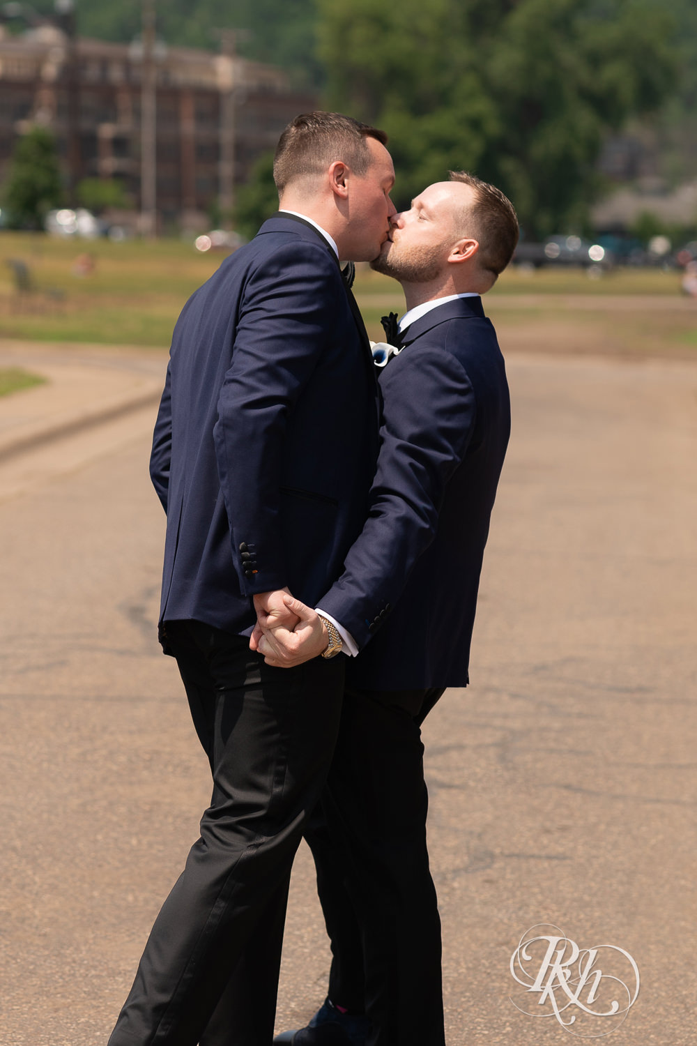 Grooms in blue tuxedos kiss before gay wedding in Stillwater, Minnesota.