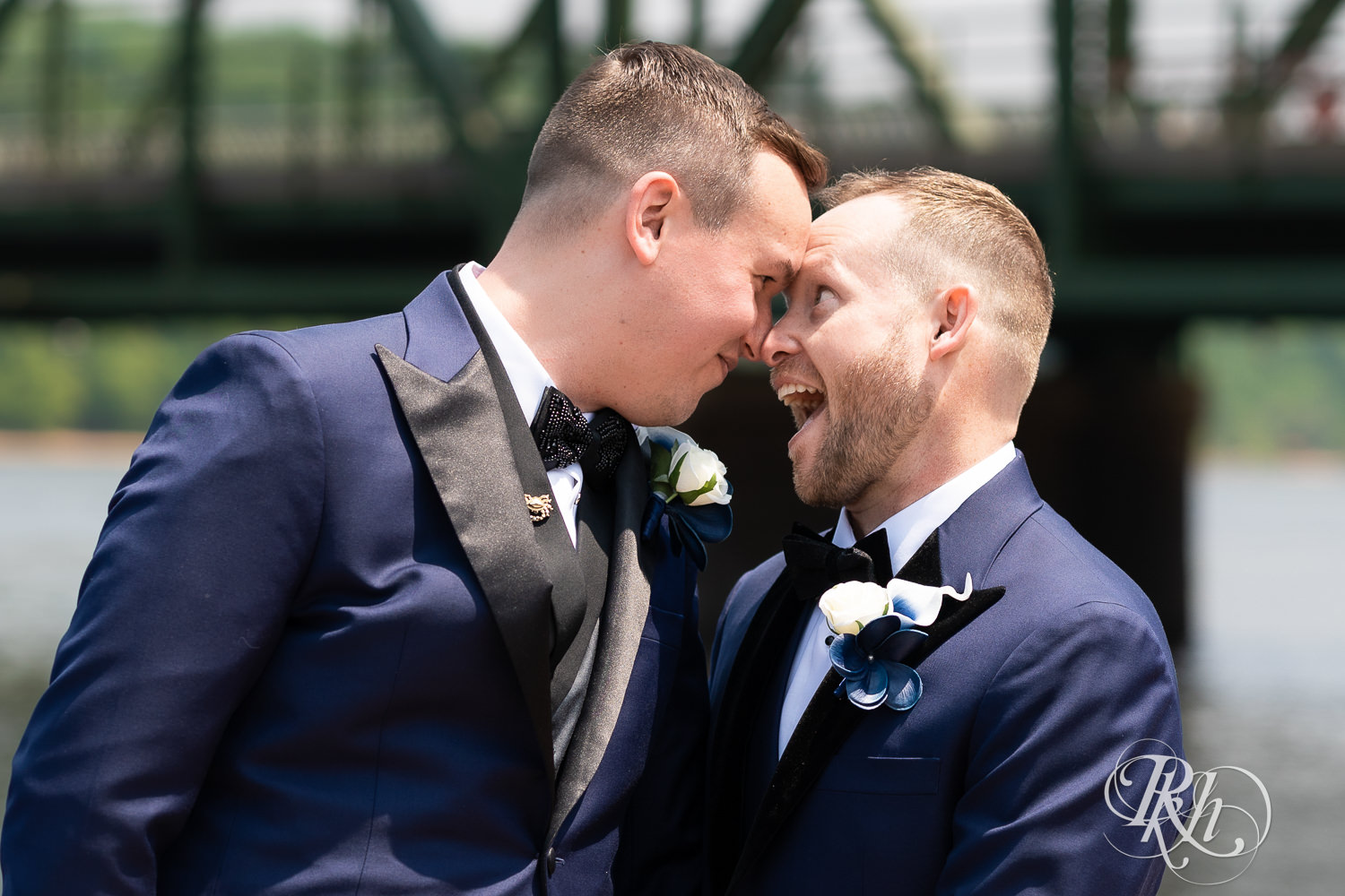 Grooms in blue tuxedos laugh before gay wedding in Stillwater, Minnesota.