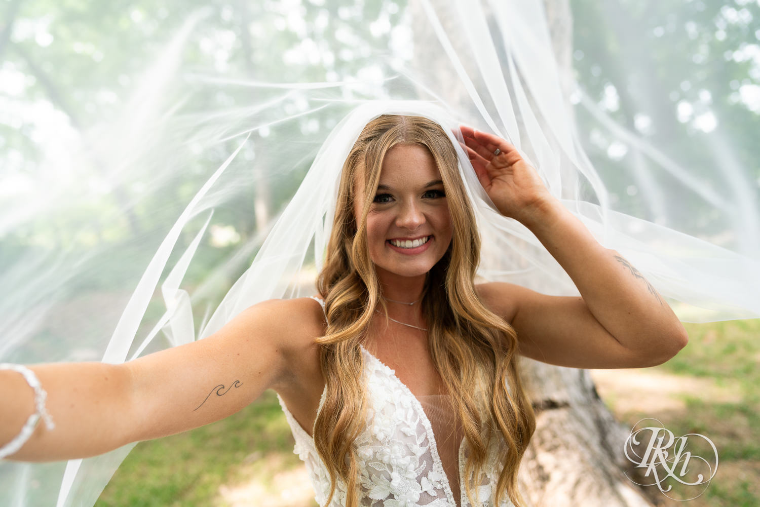 Bride smiles under veil on wedding day at Ahavah Cottage in Elysian, Minnesota.