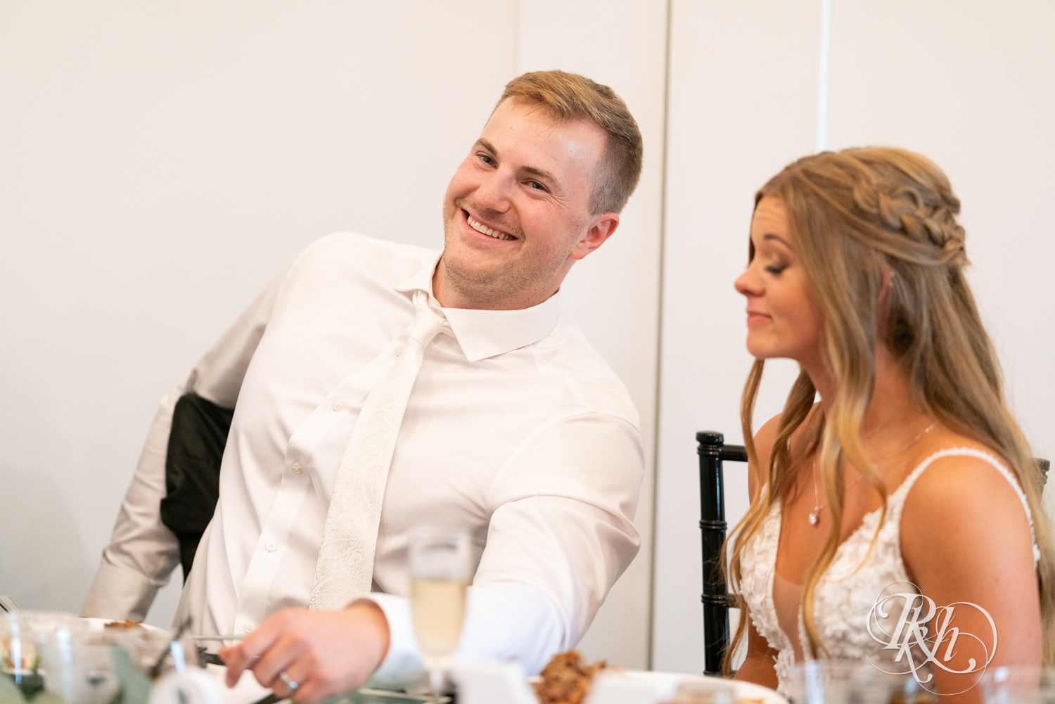 Groom laughing during wedding reception at Ahavah Cottage in Elysian, Minnesota.