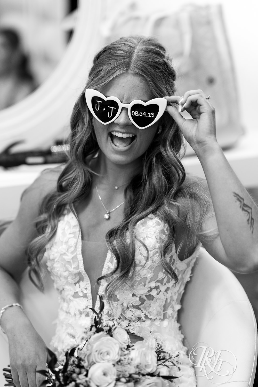 Bride laughing with sunglasses on on wedding day at Ahavah Cottage in Elysian, Minnesota.