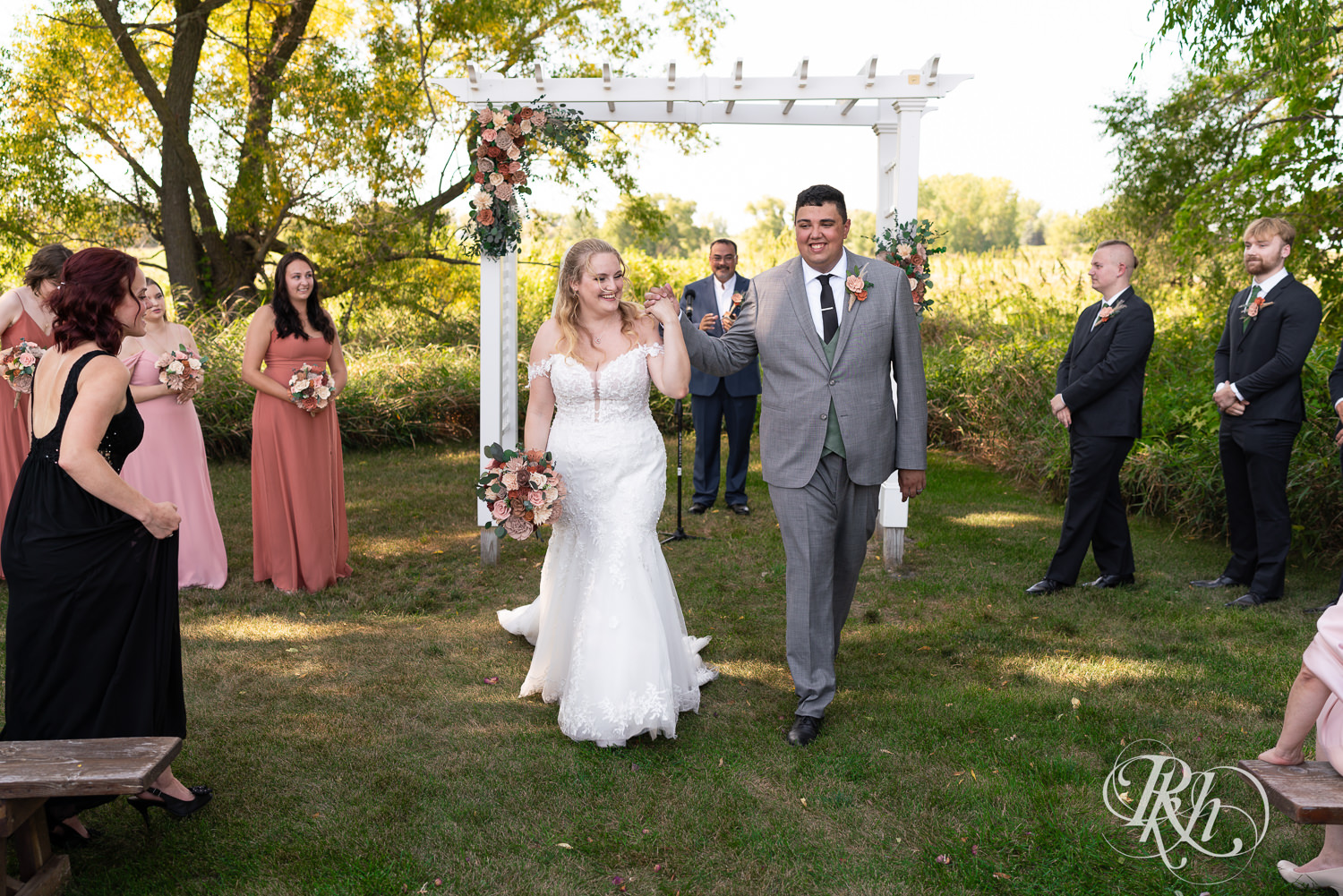 Bride and groom laugh during summer wedding ceremony at Cottage Farmhouse in Glencoe, Minnesota.