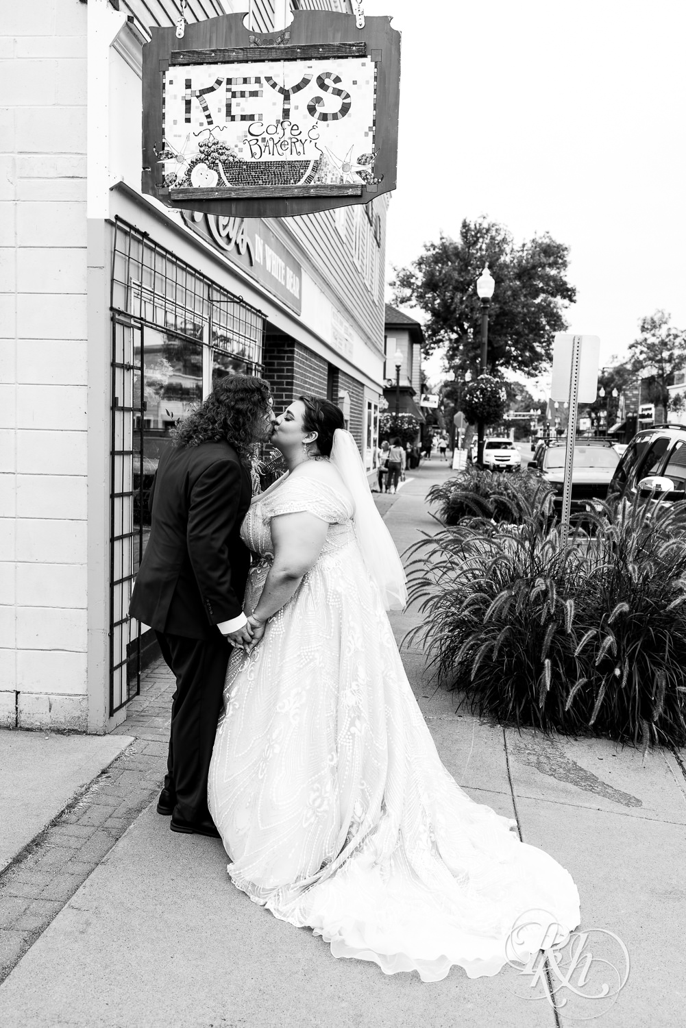 Bride and groom kiss in front of Key's Cafe in White Bear Lake, Minnesota.