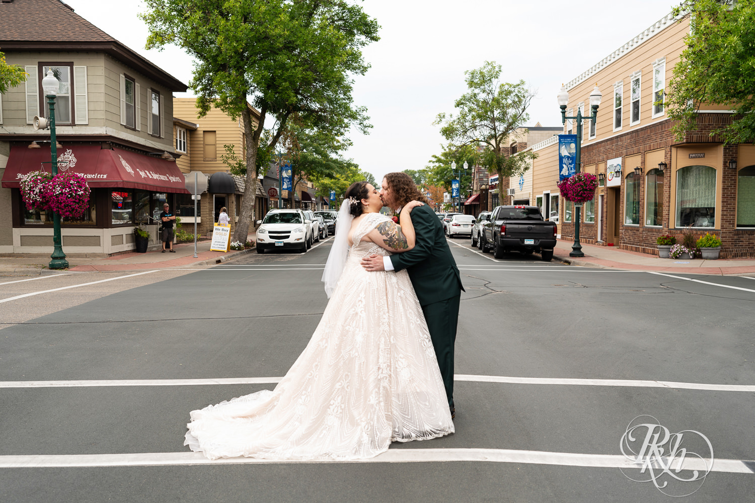 Bride and groom kiss in the street in White Bear Lake, Minnesota.