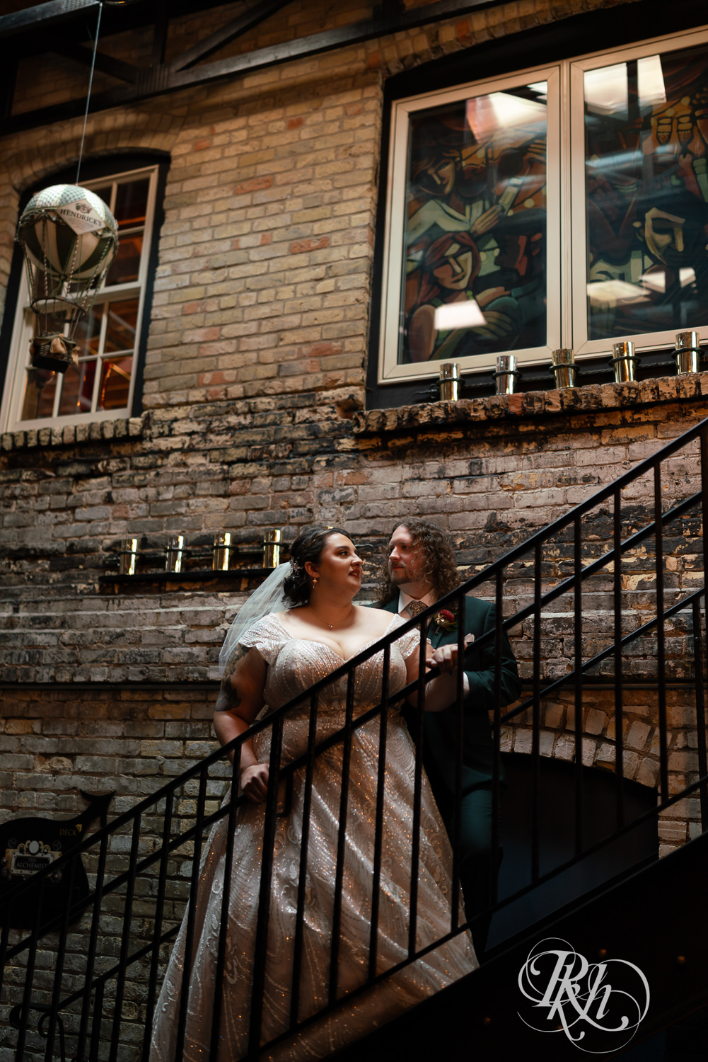 Bride and groom smile on stairs at Kellerman's Event Center in White Bear Lake, Minnesota.