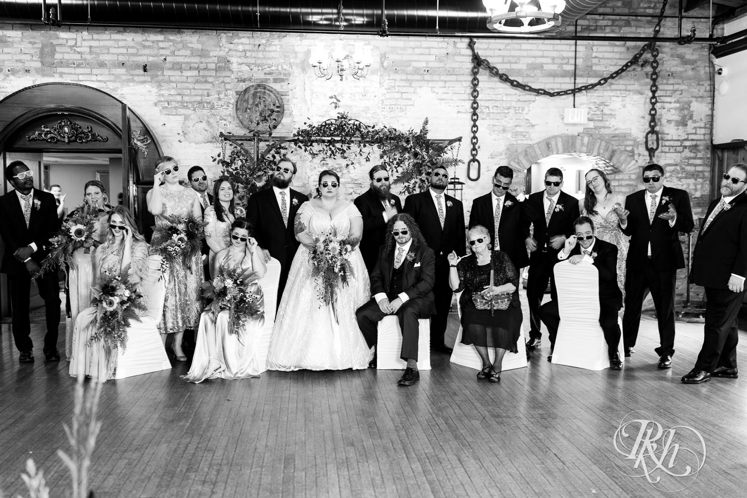 Plus size bride and groom smile wearing sunglasses with wedding party at Kellerman's Event Center in White Bear Lake, Minnesota.