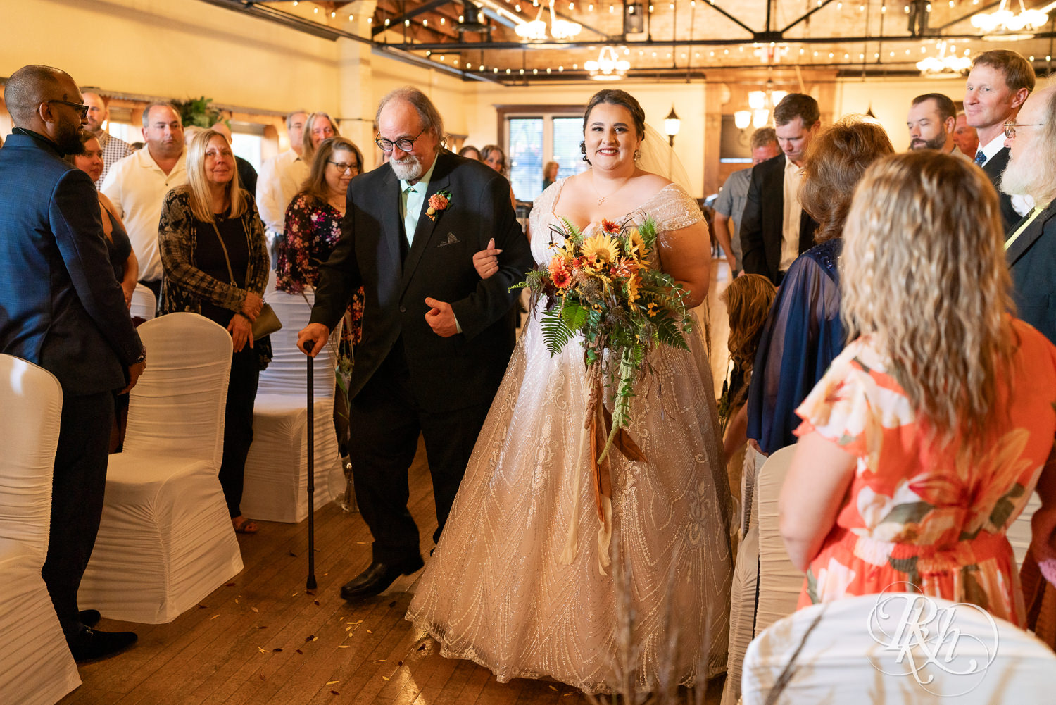 Bride walks down the aisle with her dad at Kellerman's Event Center in White Bear Lake, Minnesota.